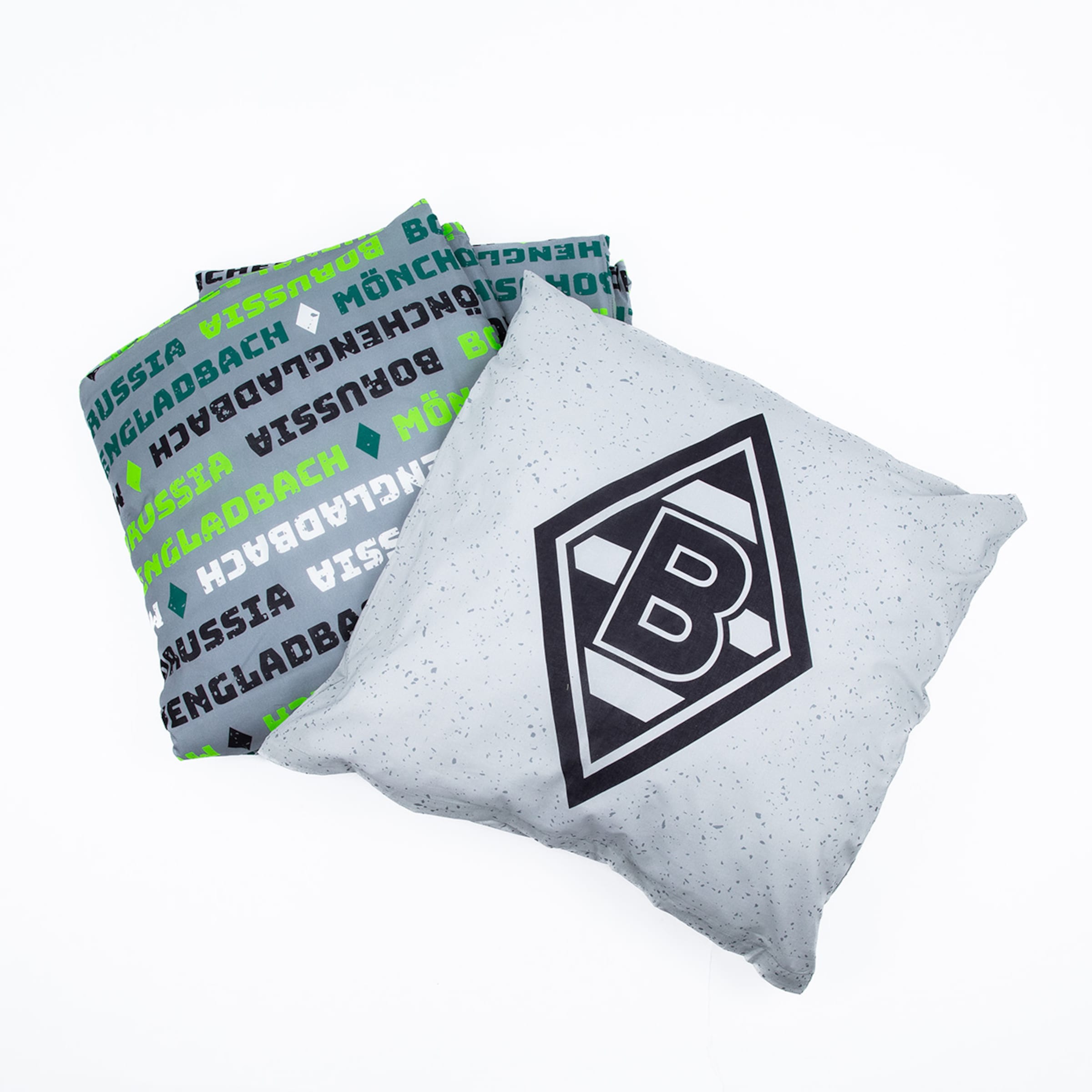 Zwei Borussia Mönchengladbach Kissen vor weißem Hintergrund: Eines hellgrau mit Rautenlogo, eines dunkelgrau mit grün-schwarzem Schriftzug-Muster.