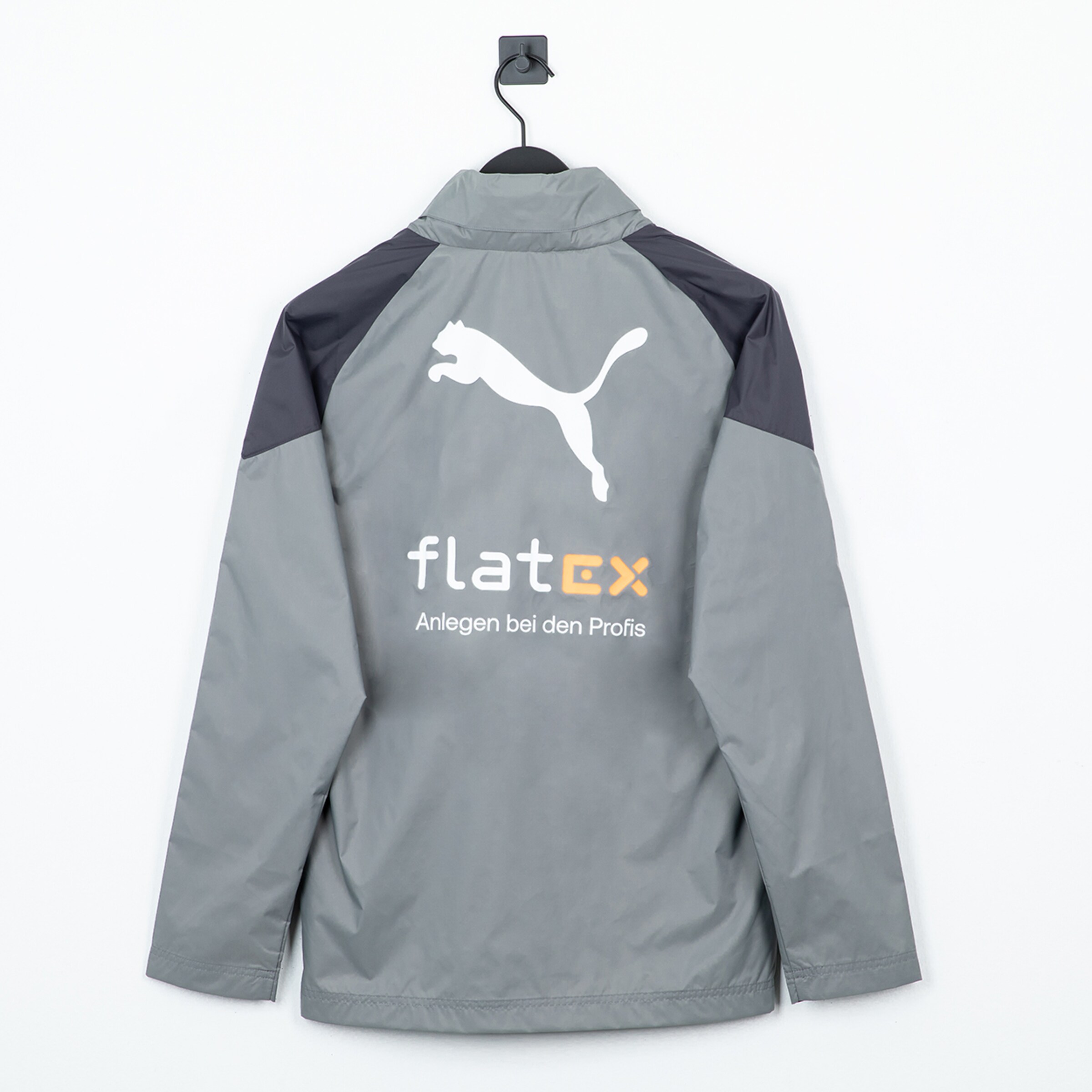 Graue Jacke mit Puma-Logo und flatex-Sponsoraufdruck auf der Rückseite