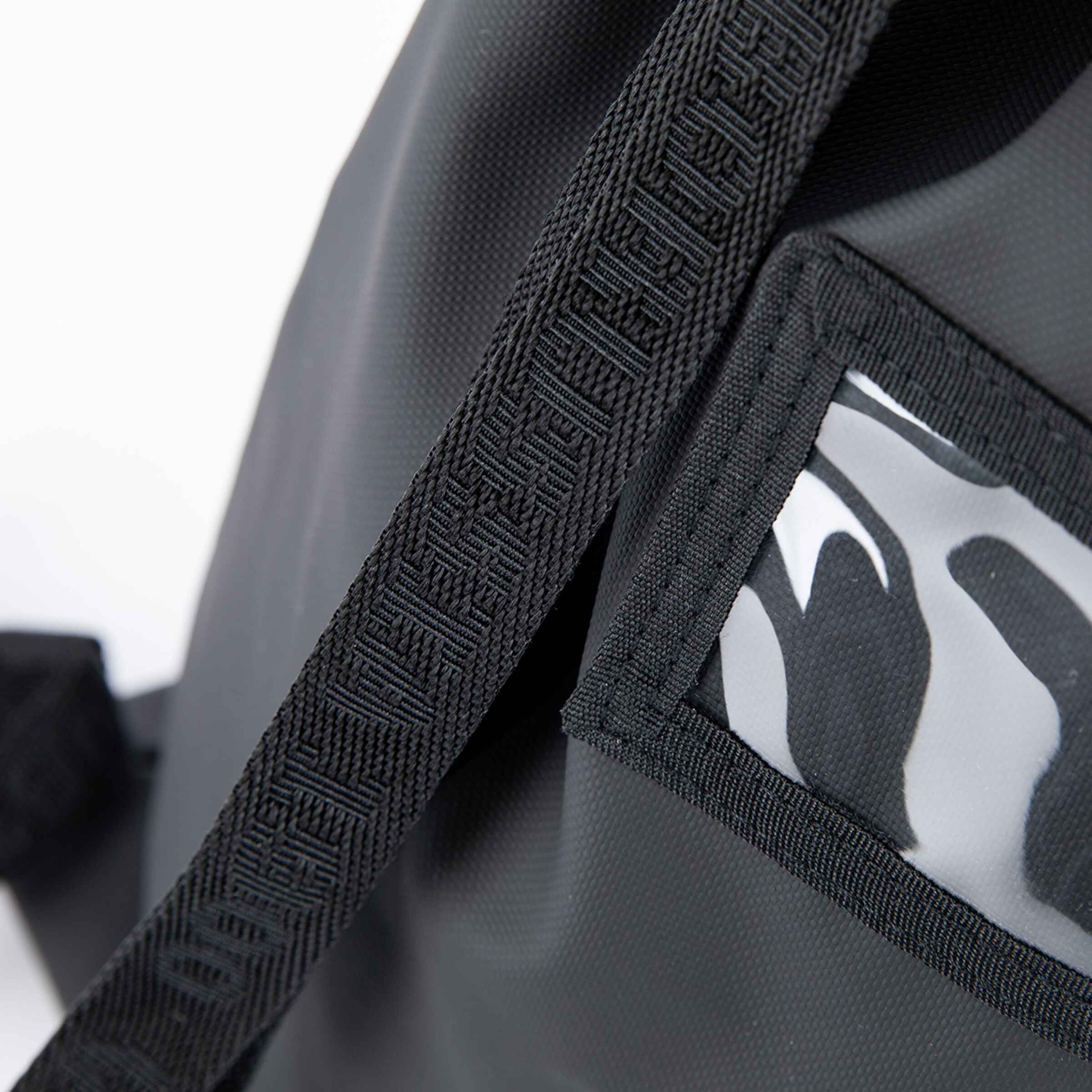 Black sports bag with a transparent pocket and textured strap