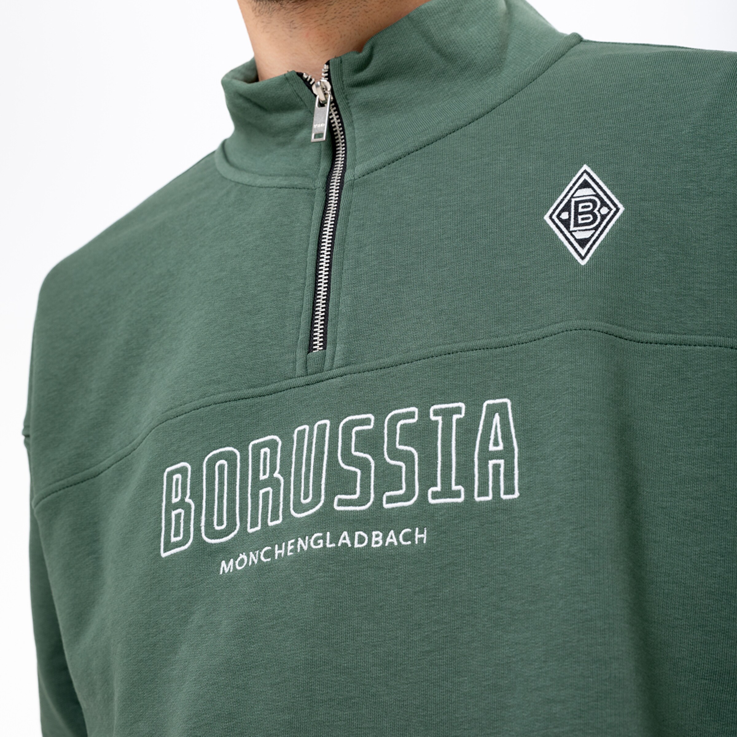 Grünes Sweatshirt mit Reißverschluss am Kragen, Borussia Mönchengladbach Logo und weißem Schriftzug auf der Brust.