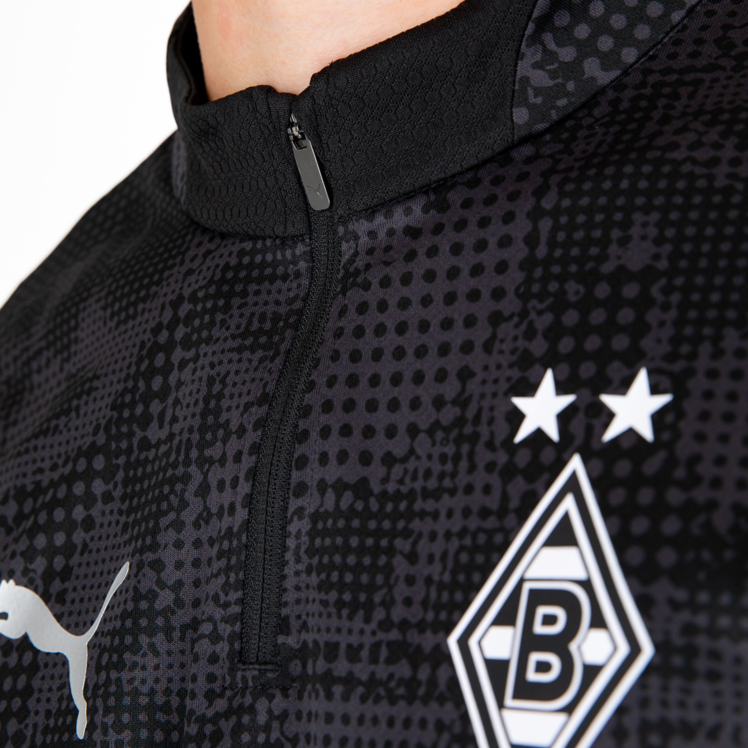 Schwarz-weißes Borussia Mönchengladbach Trikot mit Reißverschluss und Vereinslogo.