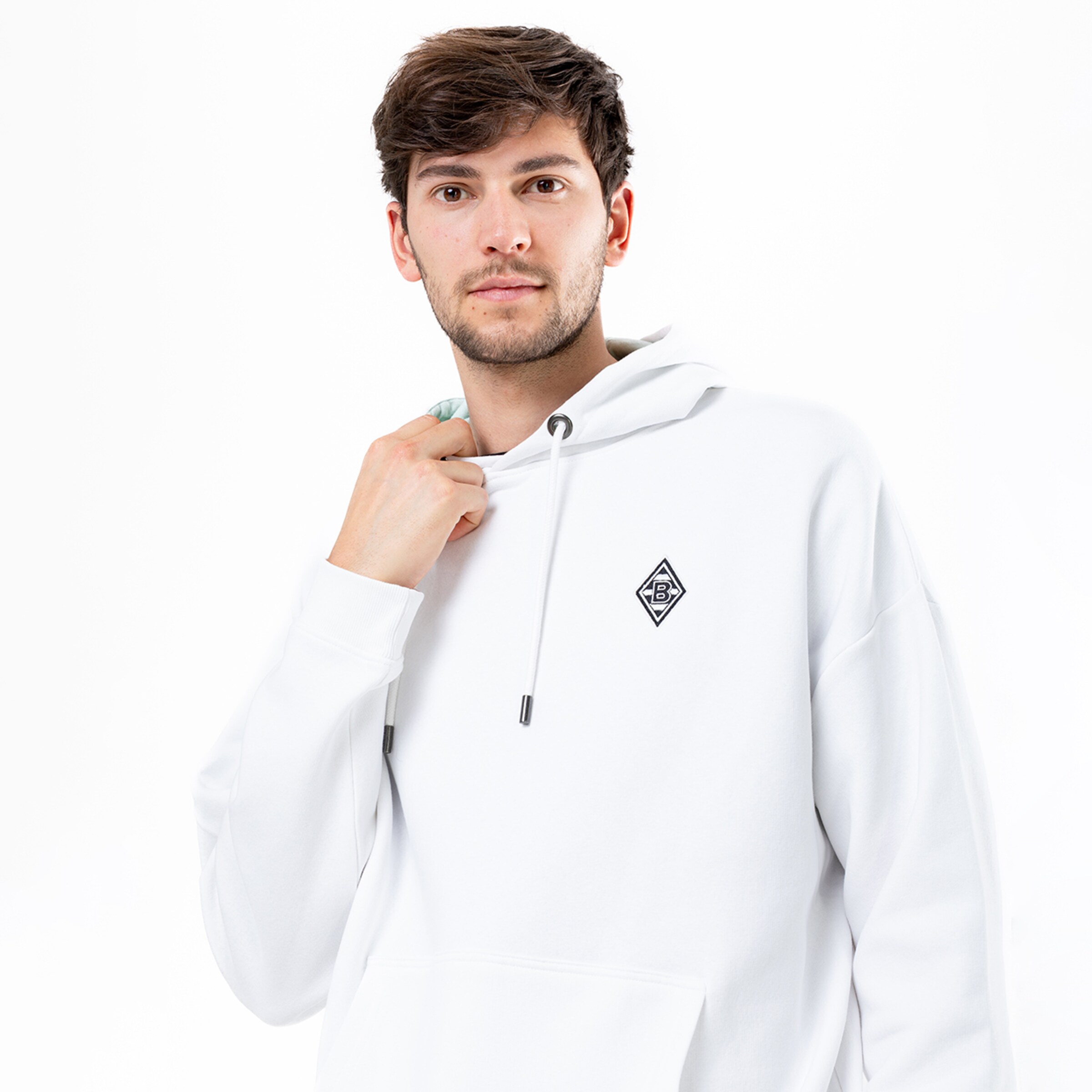 Mann trägt weißen Kapuzenpullover mit dem Borussia Mönchengladbach-Logo.