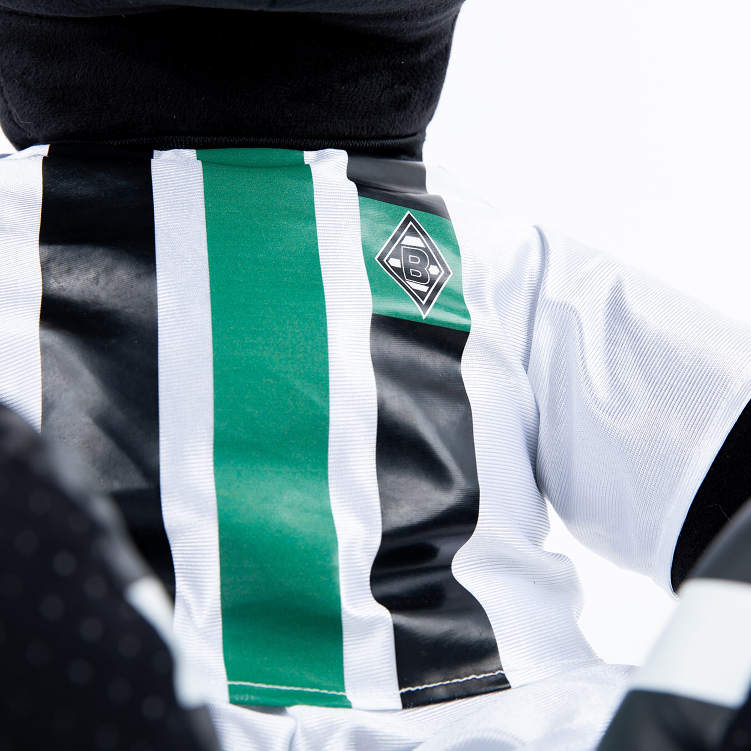 Close-up of Borussia Mönchengladbach badge on a jersey with black and white stripes and green detail.