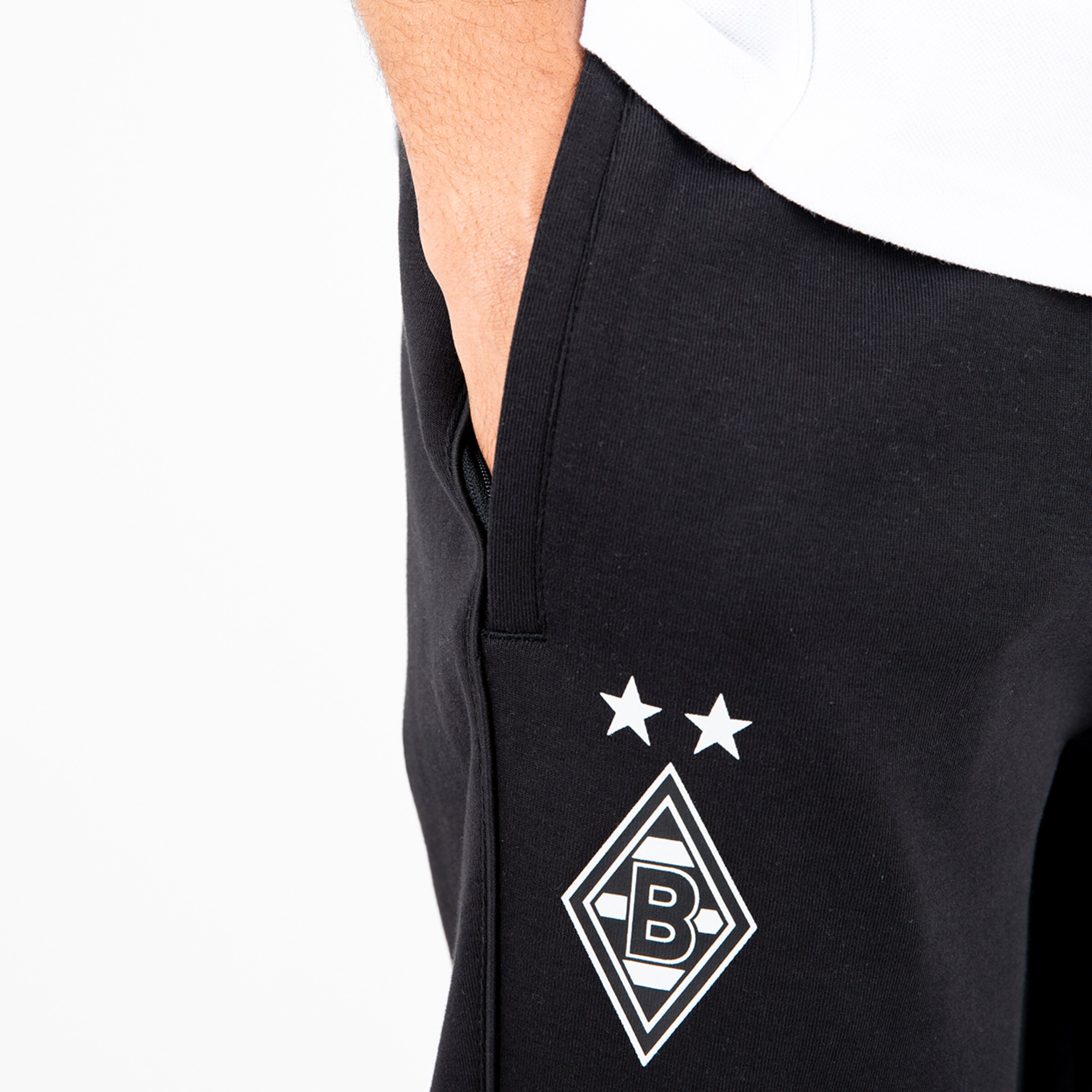 Schwarze Trainingshose mit weißem Logo von Borussia Mönchengladbach und zwei Sternen auf der Vorderseite.