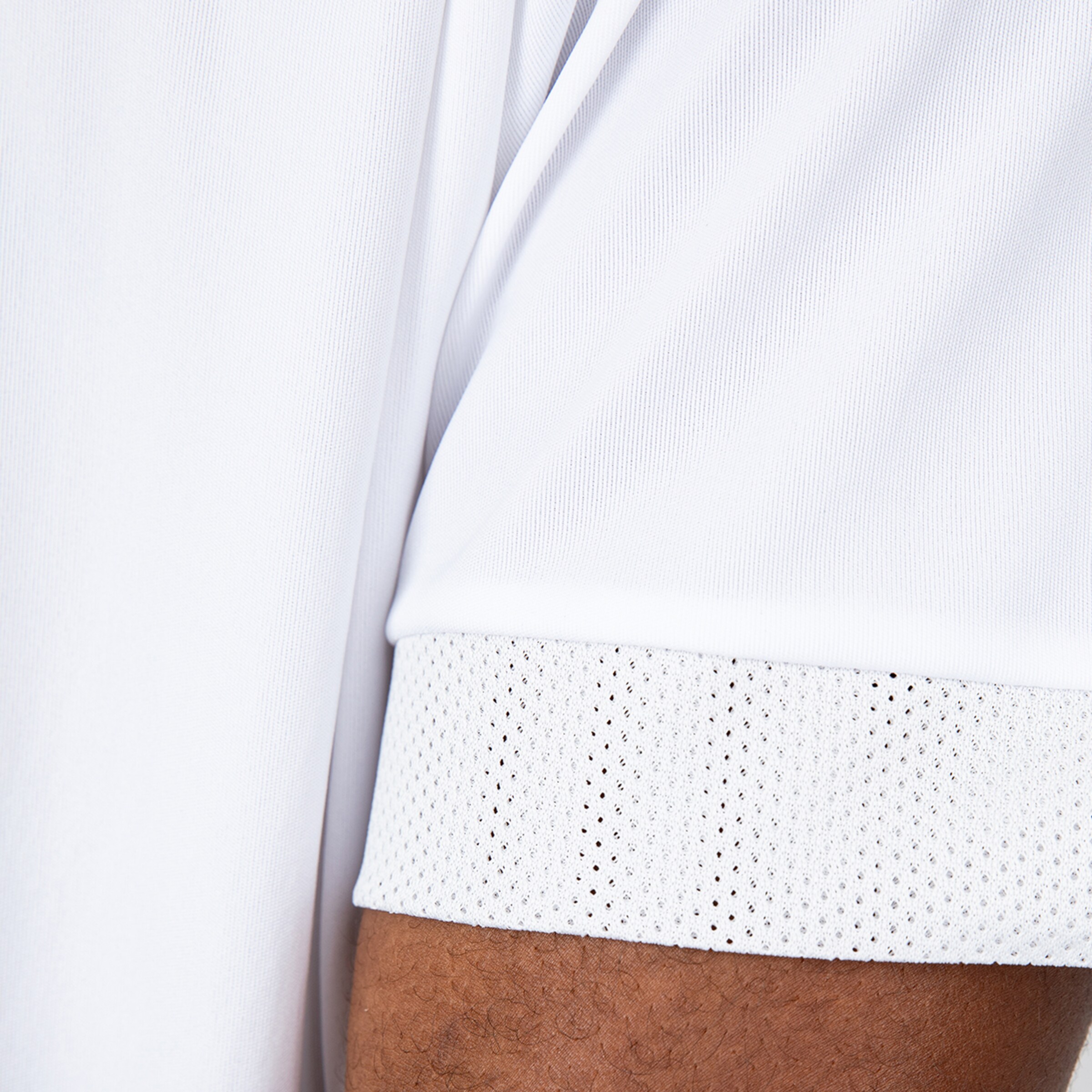 Close-up of a white jersey featuring a mesh sleeve cuff.