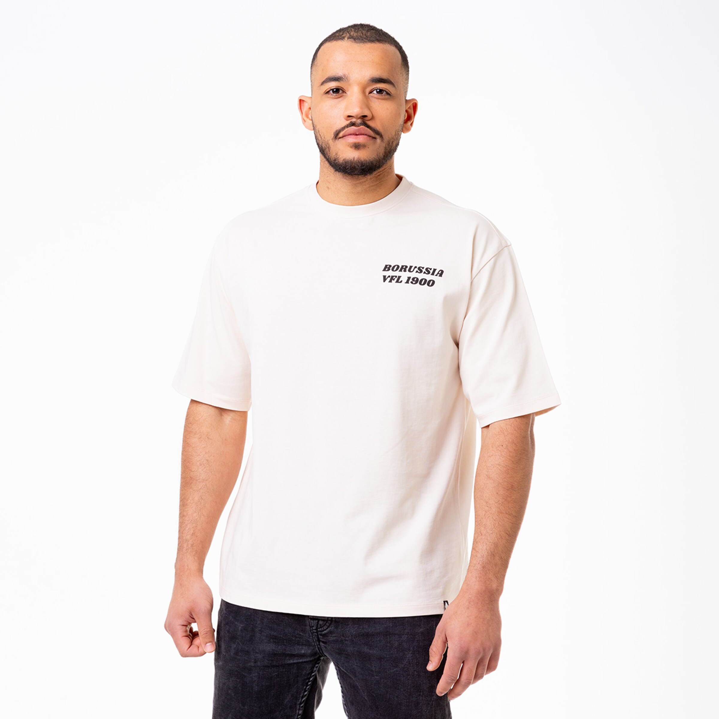 Man wearing a beige t-shirt with Borussia VFL 1900 printed on it.