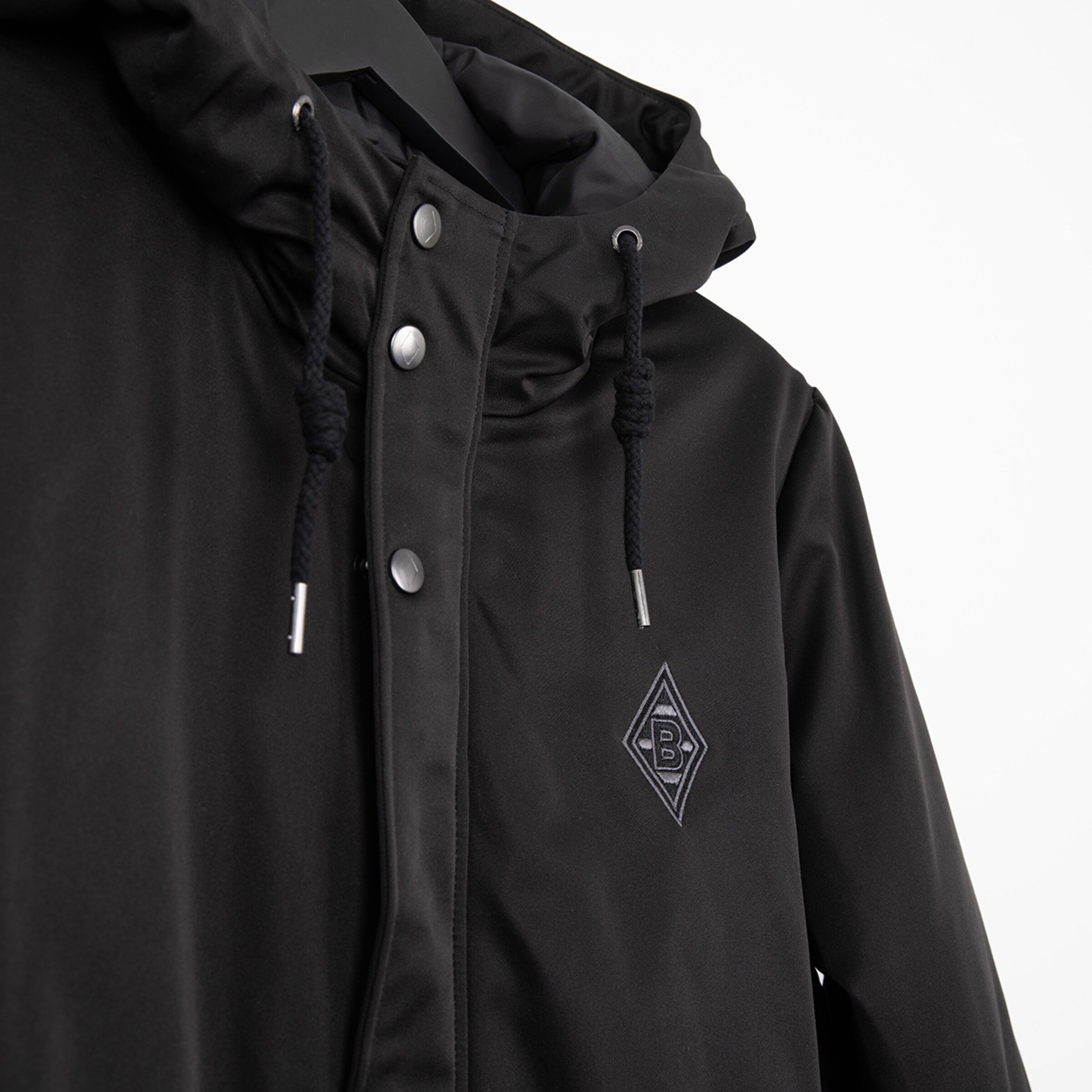 Schwarze Jacke mit Kapuze und Logo von Borussia Mönchengladbach.