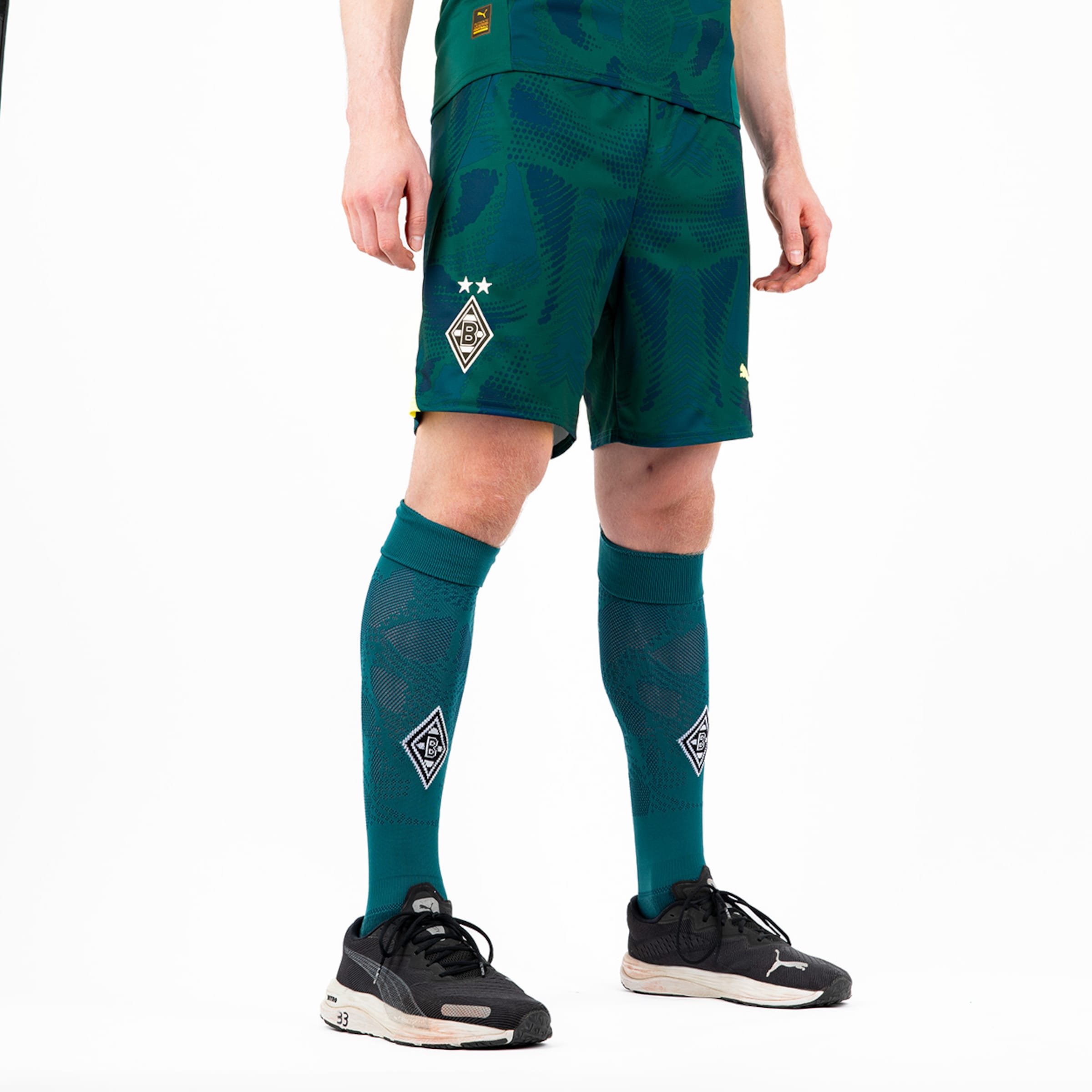 Ein Spieler trägt grüne Fußballshorts und Socken mit dem Borussia Mönchengladbach-Logo.