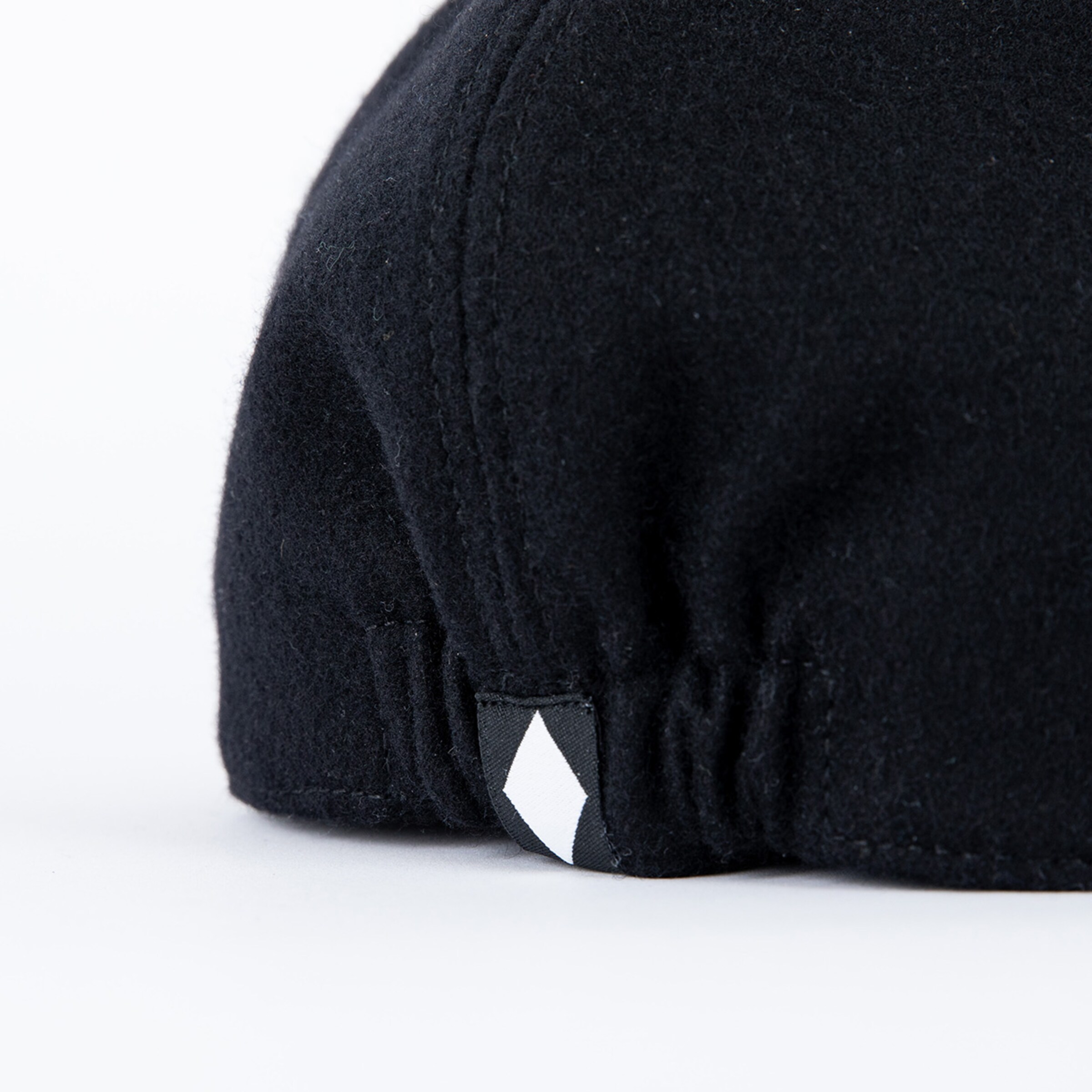 Schwarze Wollmütze mit einem kleinen Diamant-Logo.