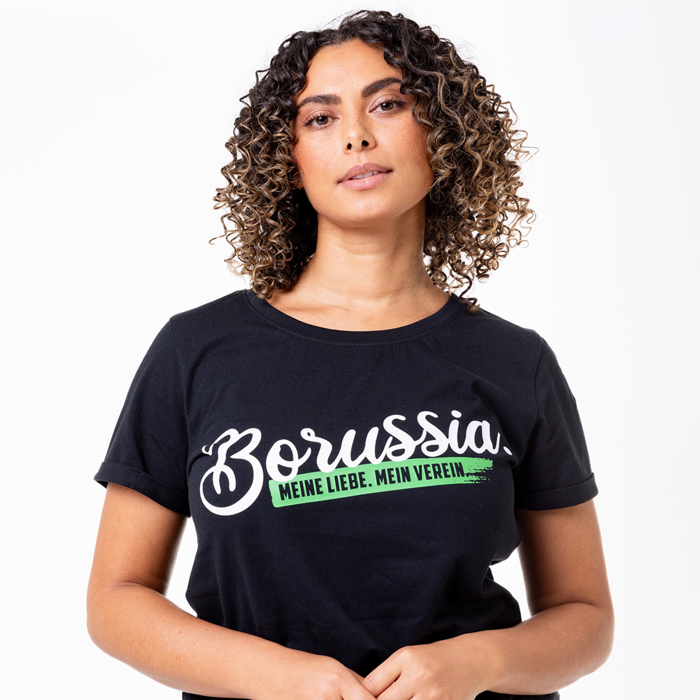 Woman with curly hair wearing a black t-shirt featuring the text Borussia. Meine Liebe. Mein Verein.