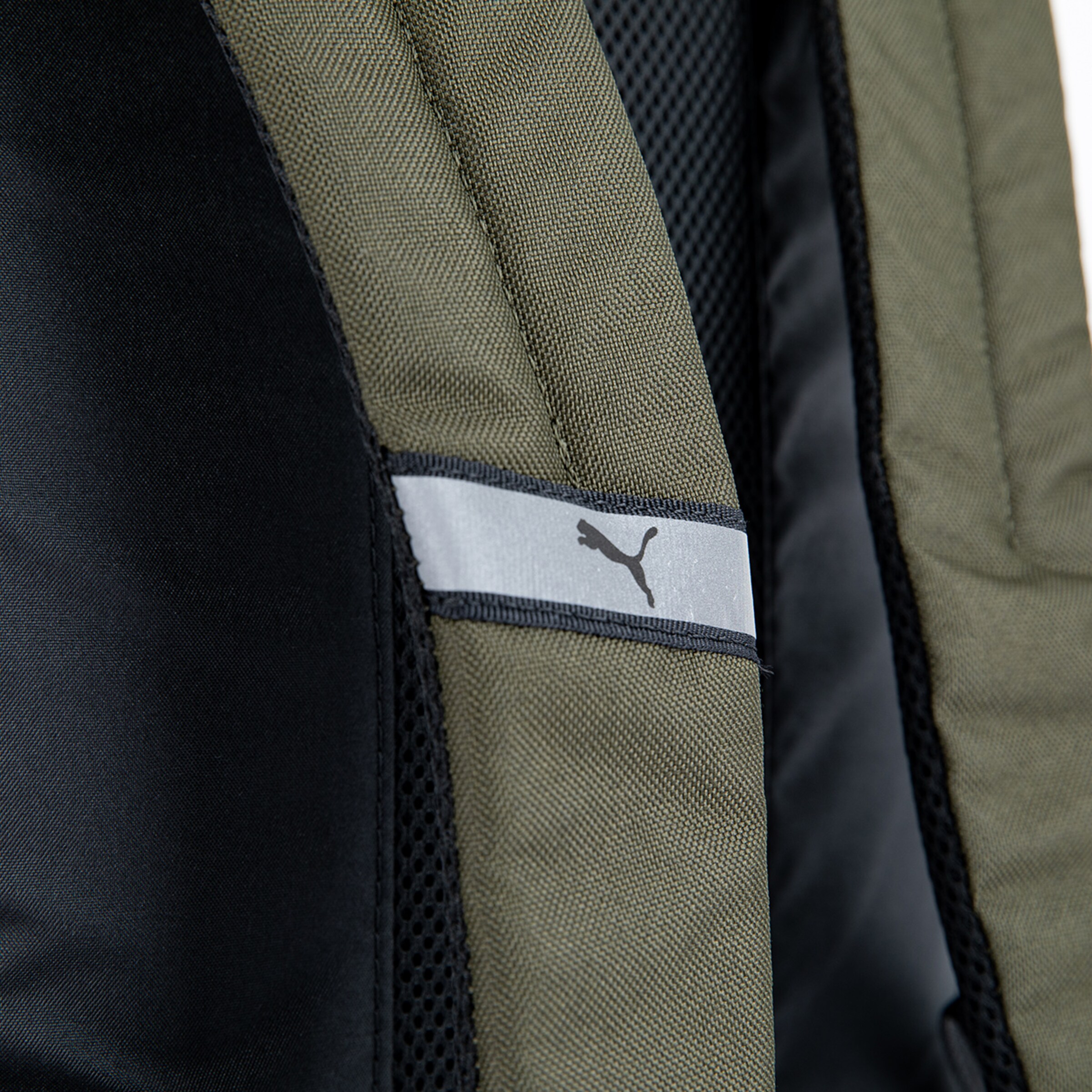 Detailansicht eines Rucksacks mit Puma-Logo auf einem Grau-Waschtuch.