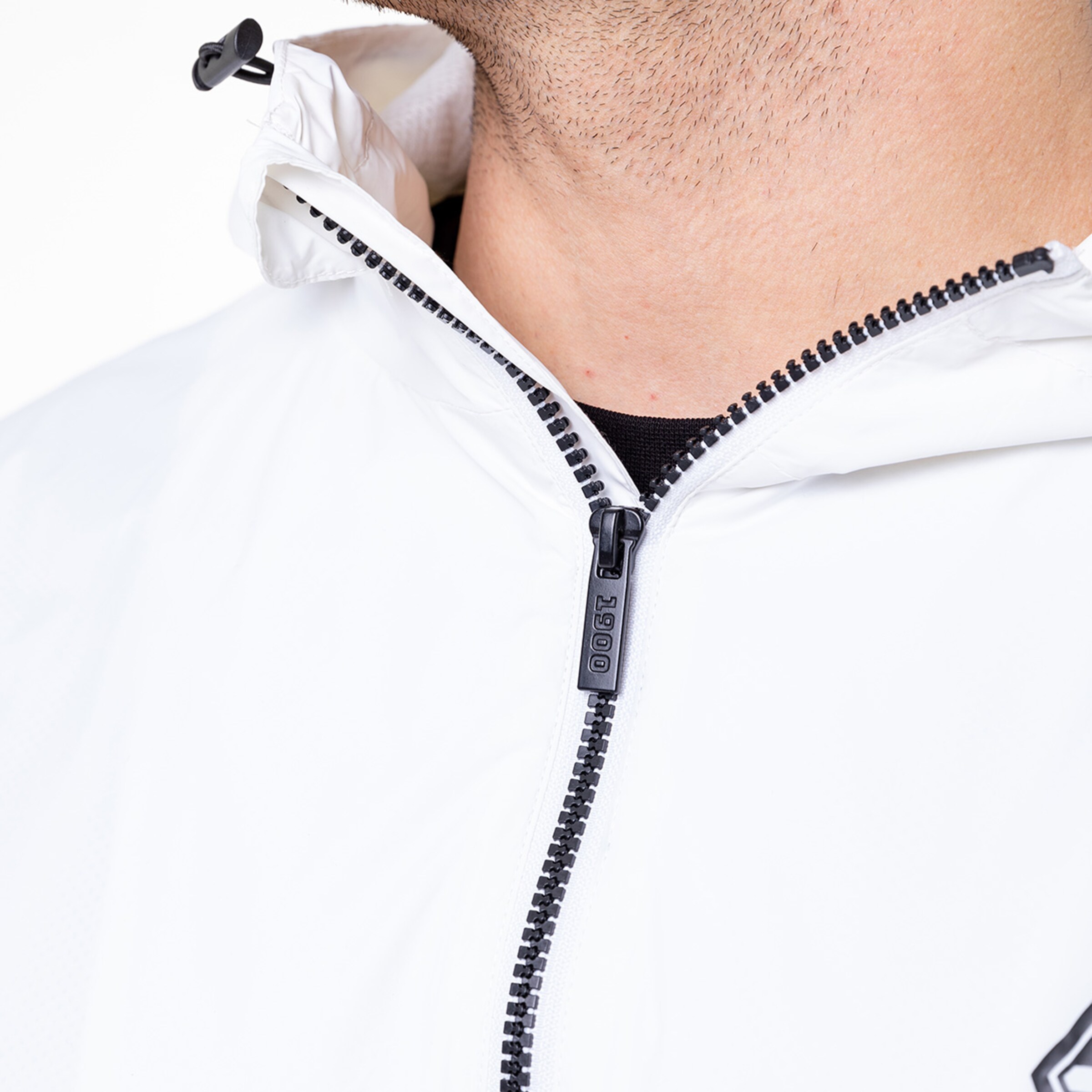 Close-up of a man in a white jacket with a zippered collar.