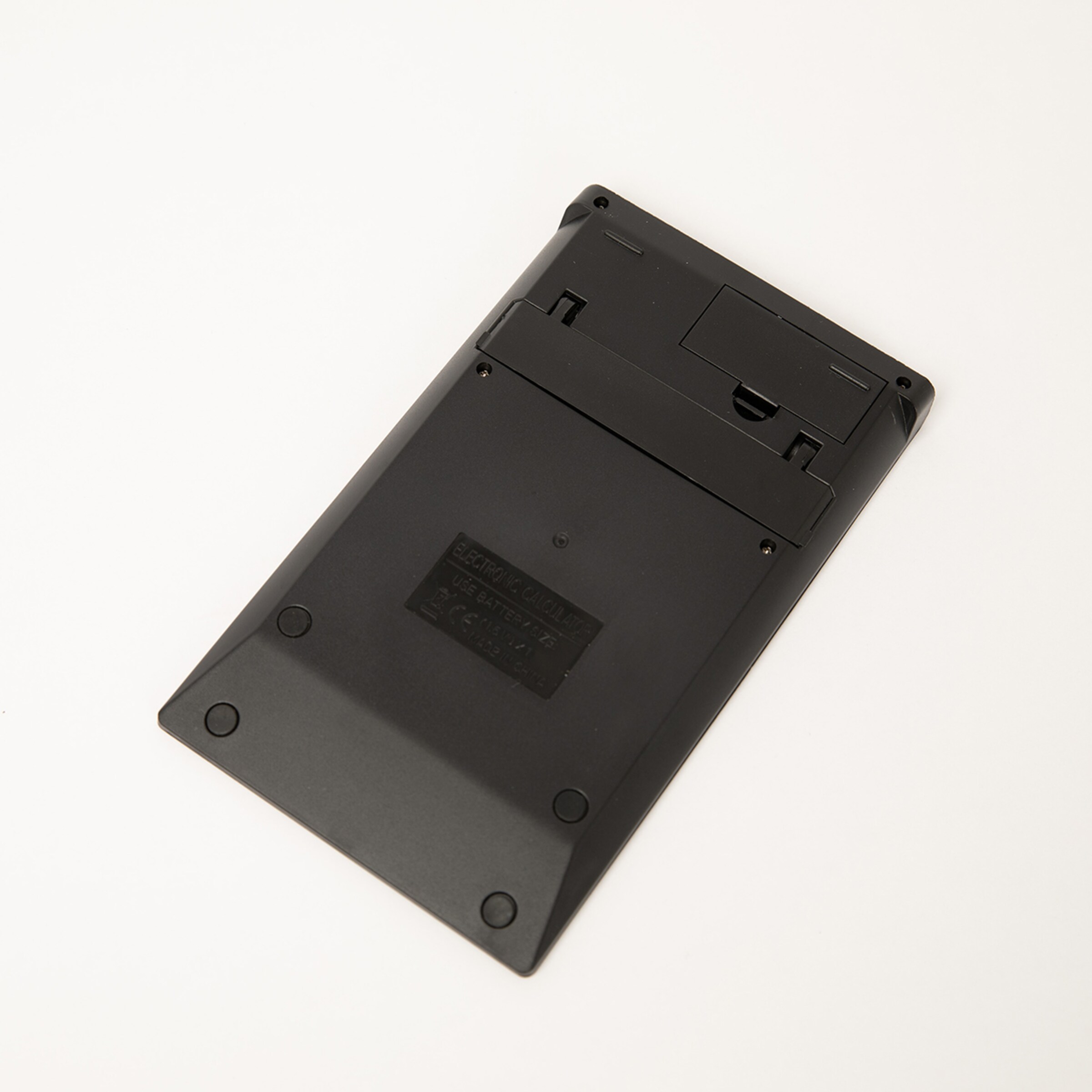 Rückseite eines schwarzen flachen Objekts mit vier Schrauben und einer Öffnung.