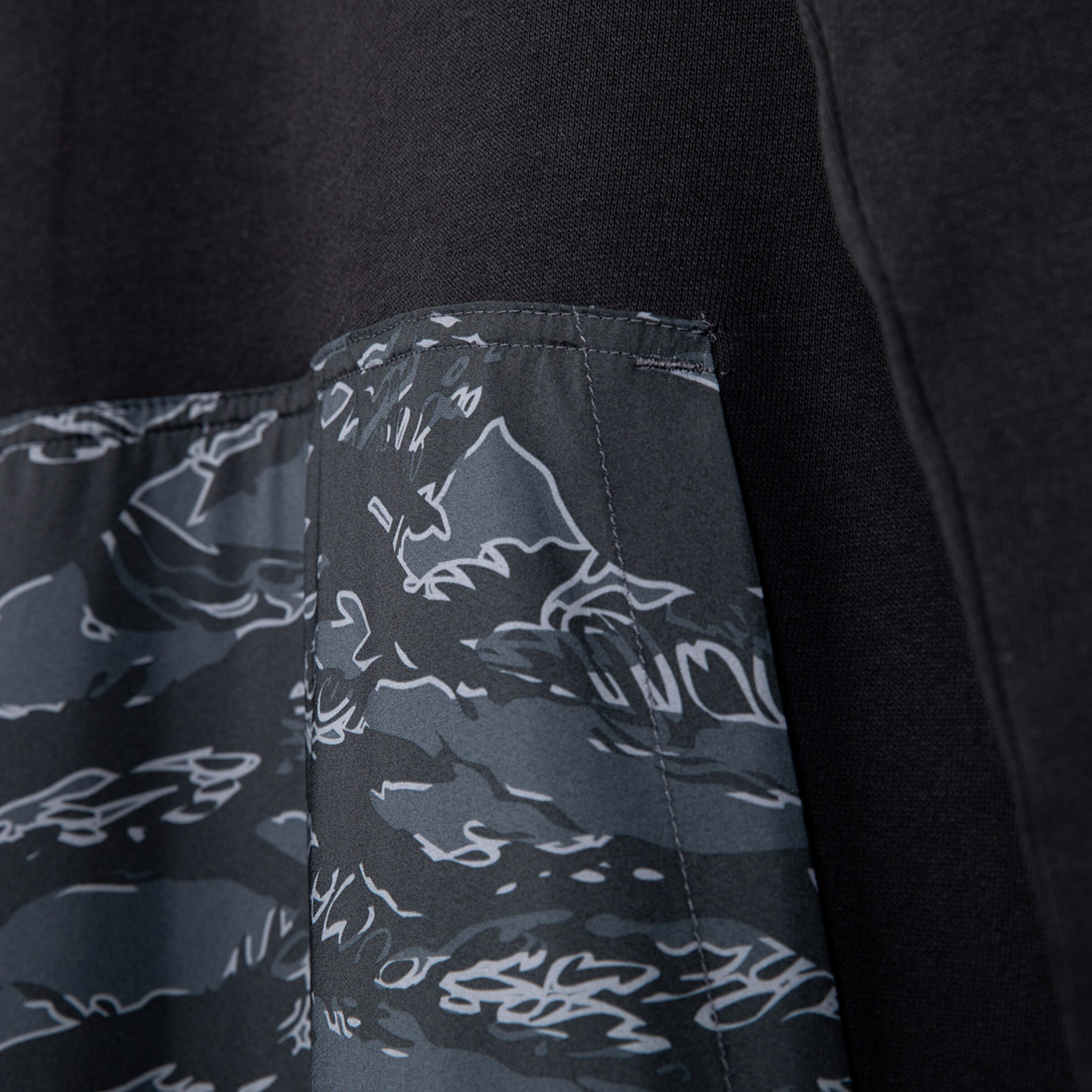 Detailansicht eines schwarz-grauen Sweatshirts mit grafischem Muster.