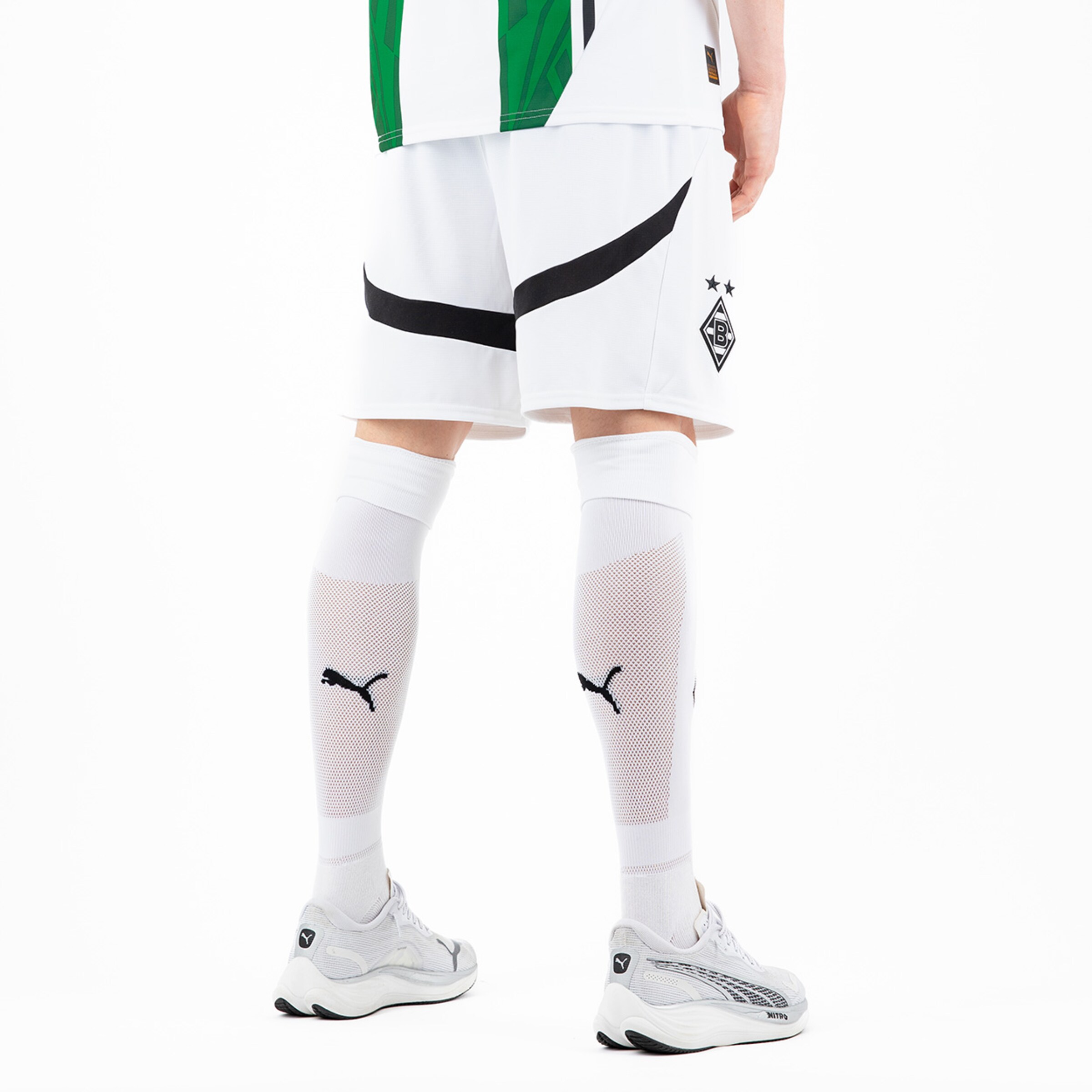 Sportlicher Spieler in Borussia Mönchengladbach Trikot mit weißen Shorts und langen weißen Socken von Puma.