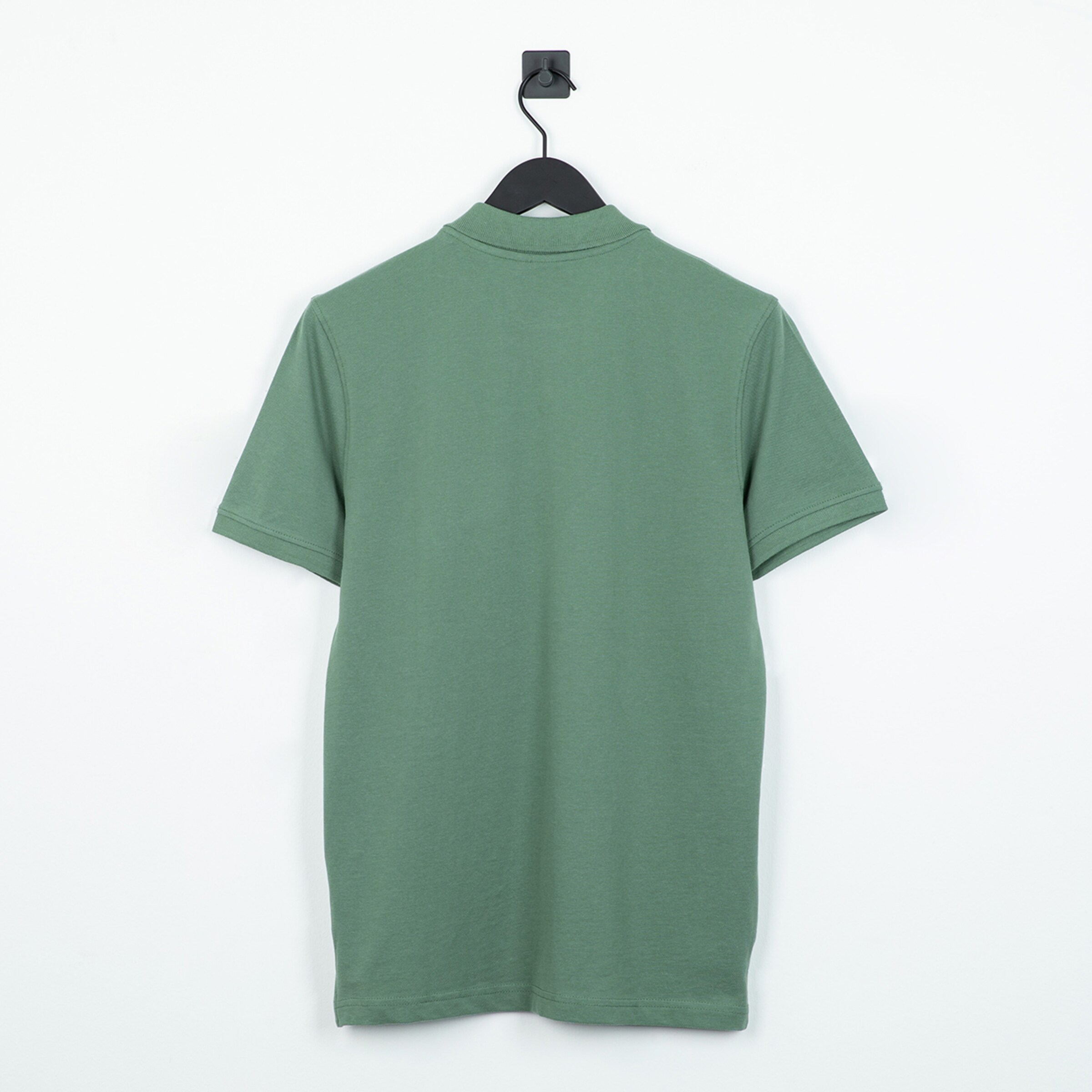 Grünes T-Shirt von hinten mit kurzen Ärmeln und Kragen auf einem Kleiderbügel.