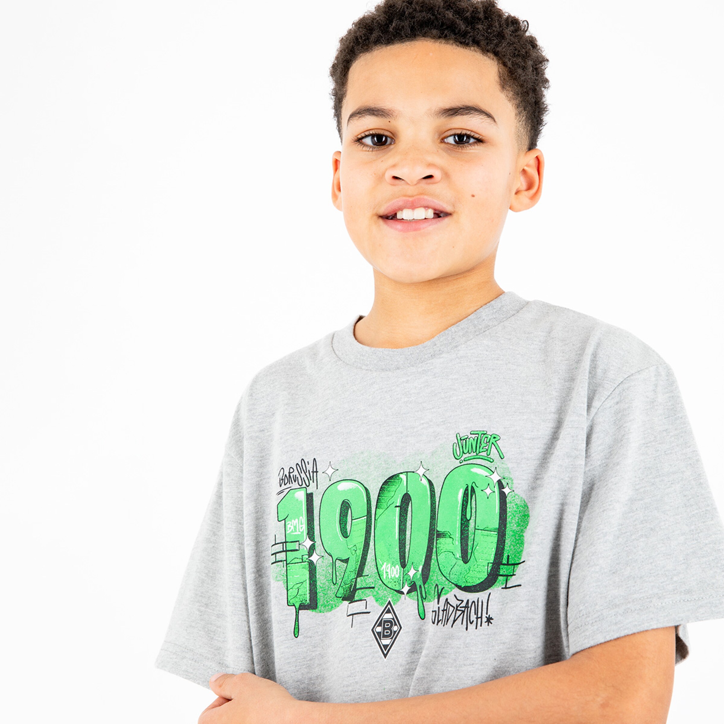 Junge trägt graues T-Shirt mit grünem Graffiti-Design und Logo von Borussia Mönchengladbach.