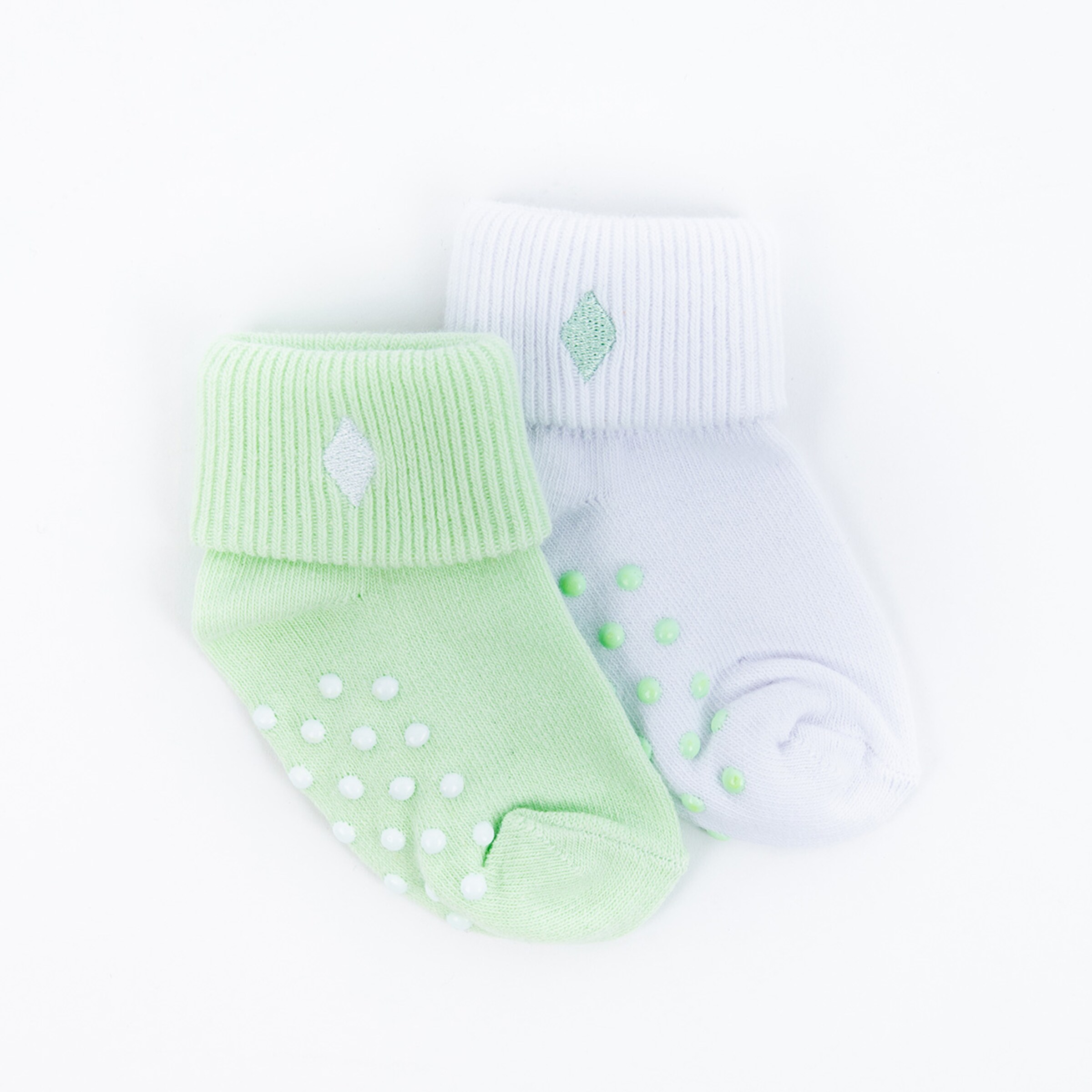 Grüne und weiße Socken mit Punkten und Rippstruktur.