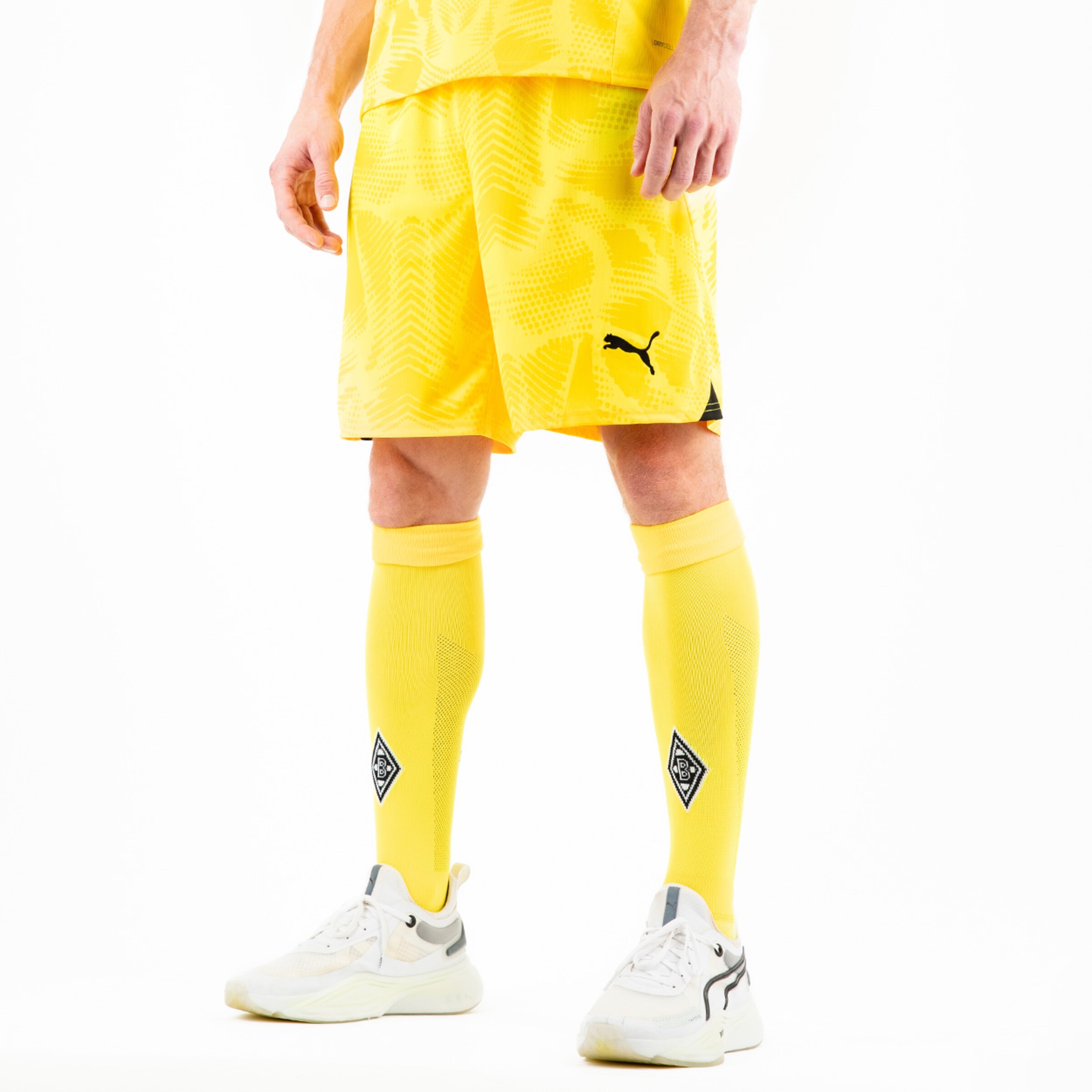 Spieler trägt gelbes Puma-Trikot und kurze Hose dazu gelbe Socken mit Logo.