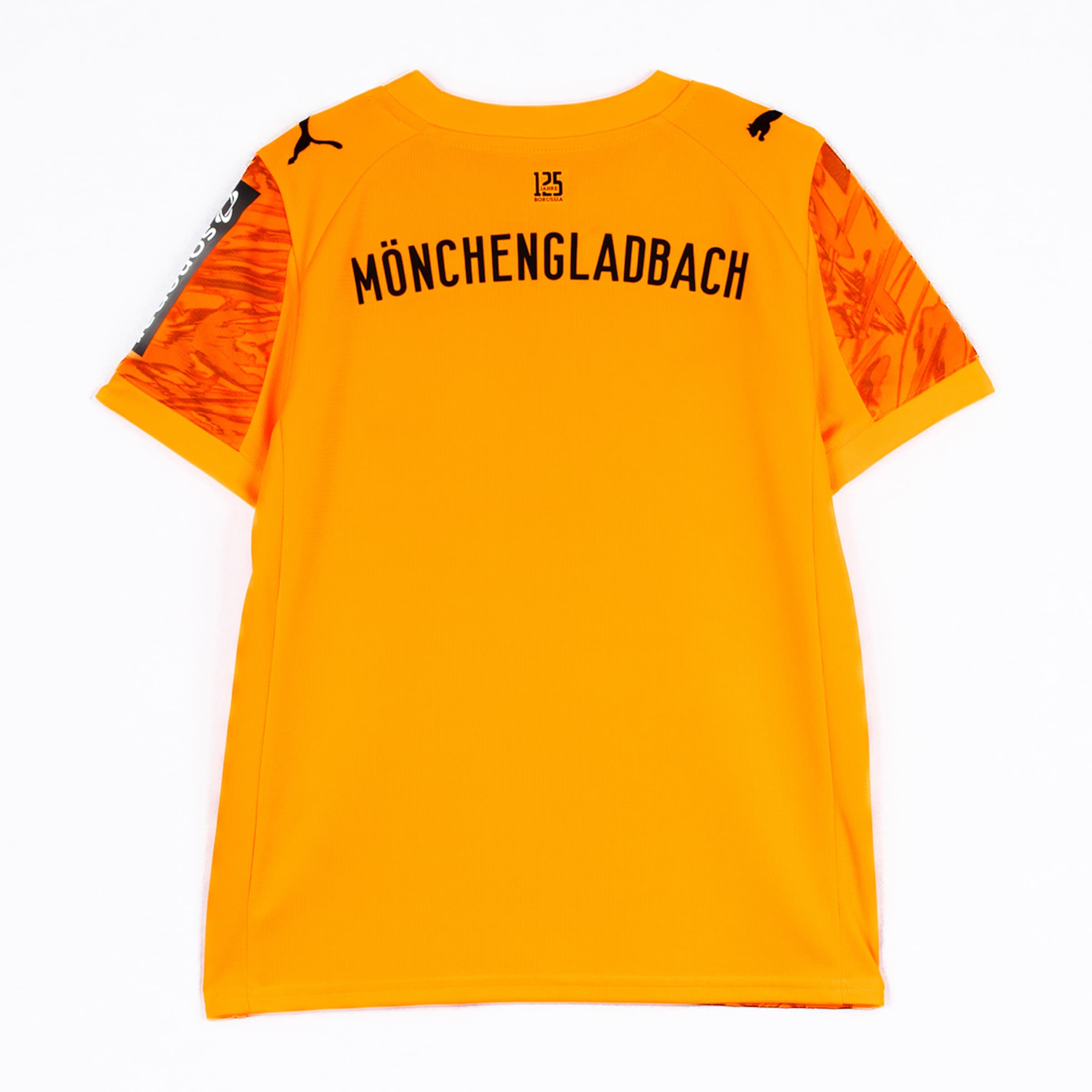 Rückansicht eines leuchtend orangefarbenen Fussballtrikots von Borussia Mönchengladbach mit dem Namen Mönchengladbach auf dem Rücken.