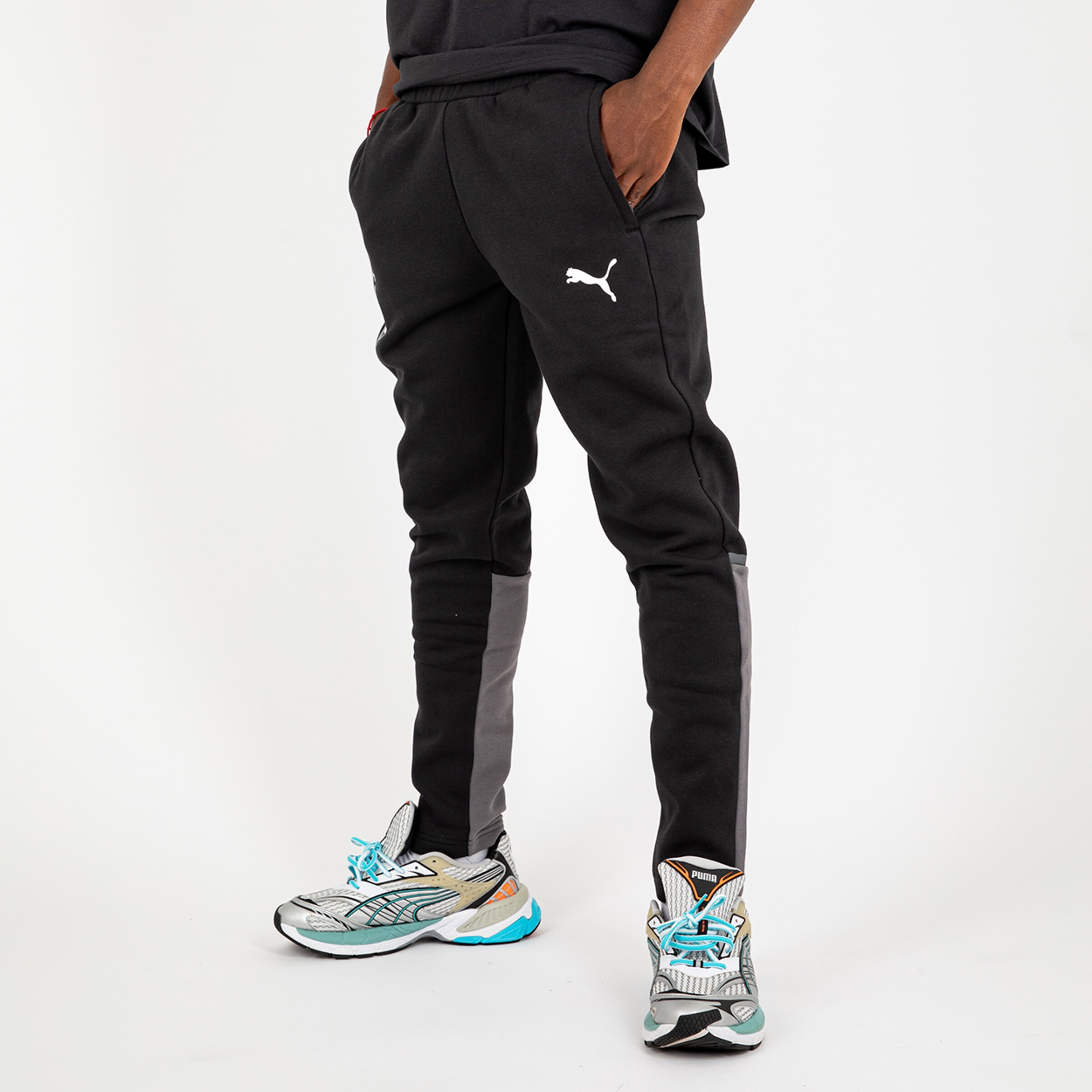 Schwarze Trainingshose von Puma mit grauen Einsätzen und weitem Schnitt.