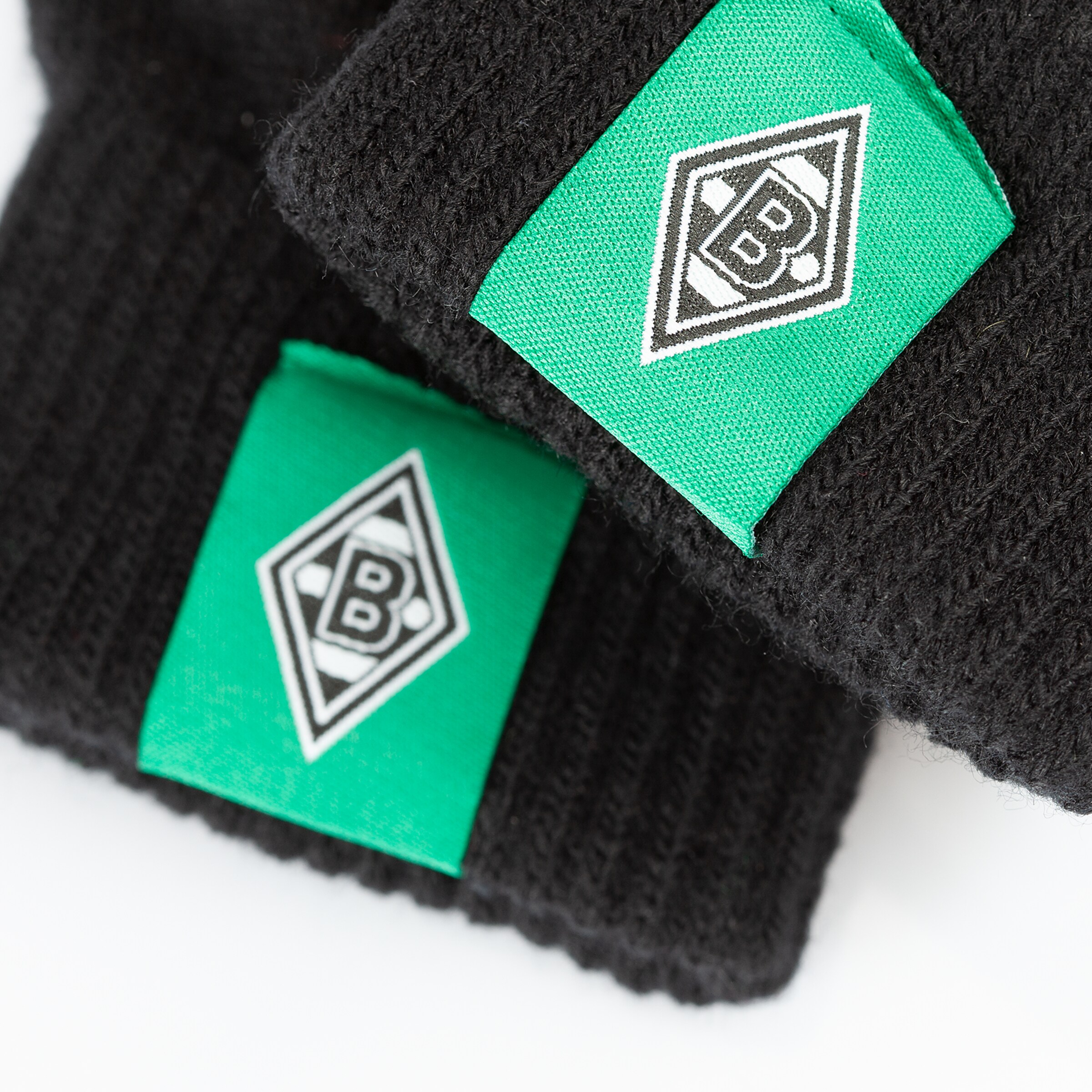 Schwarze Mütze mit grünem Aufnäher des Borussia Mönchengladbach Logos.