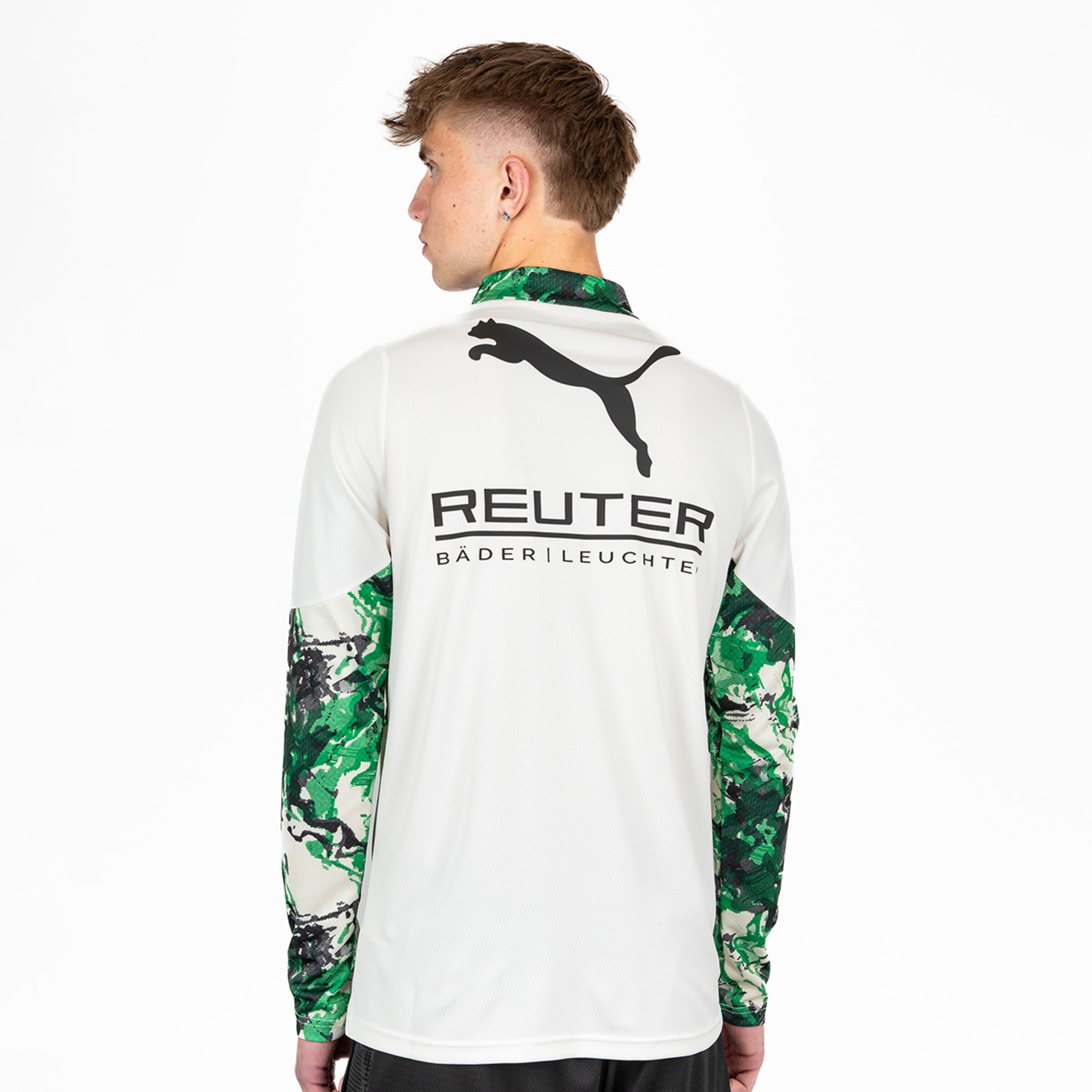 Rückansicht eines jungen Mannes in einem langen Sportoberteil mit PUMA-Logo und graugrünen Ärmeln.