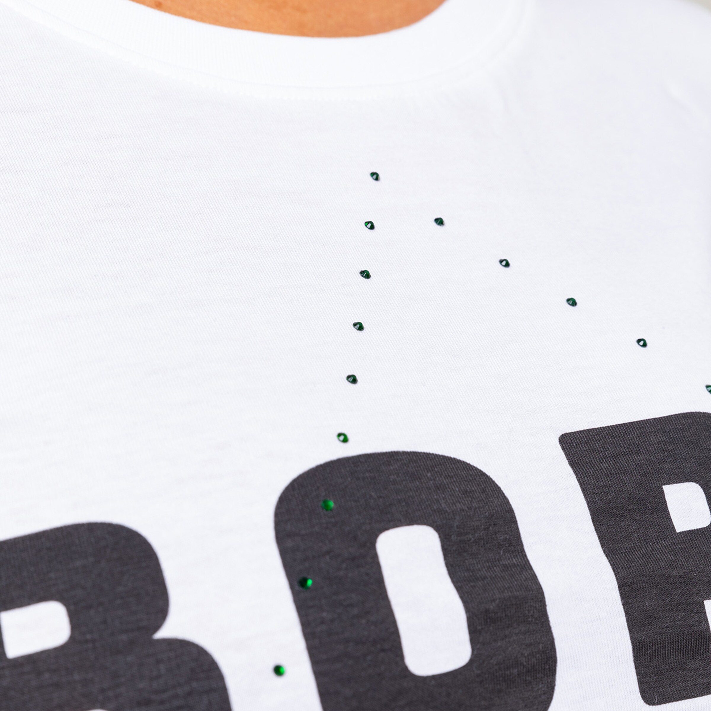 Close-up of a T-shirt featuring the word BORUSSIA adorned with green rhinestones.