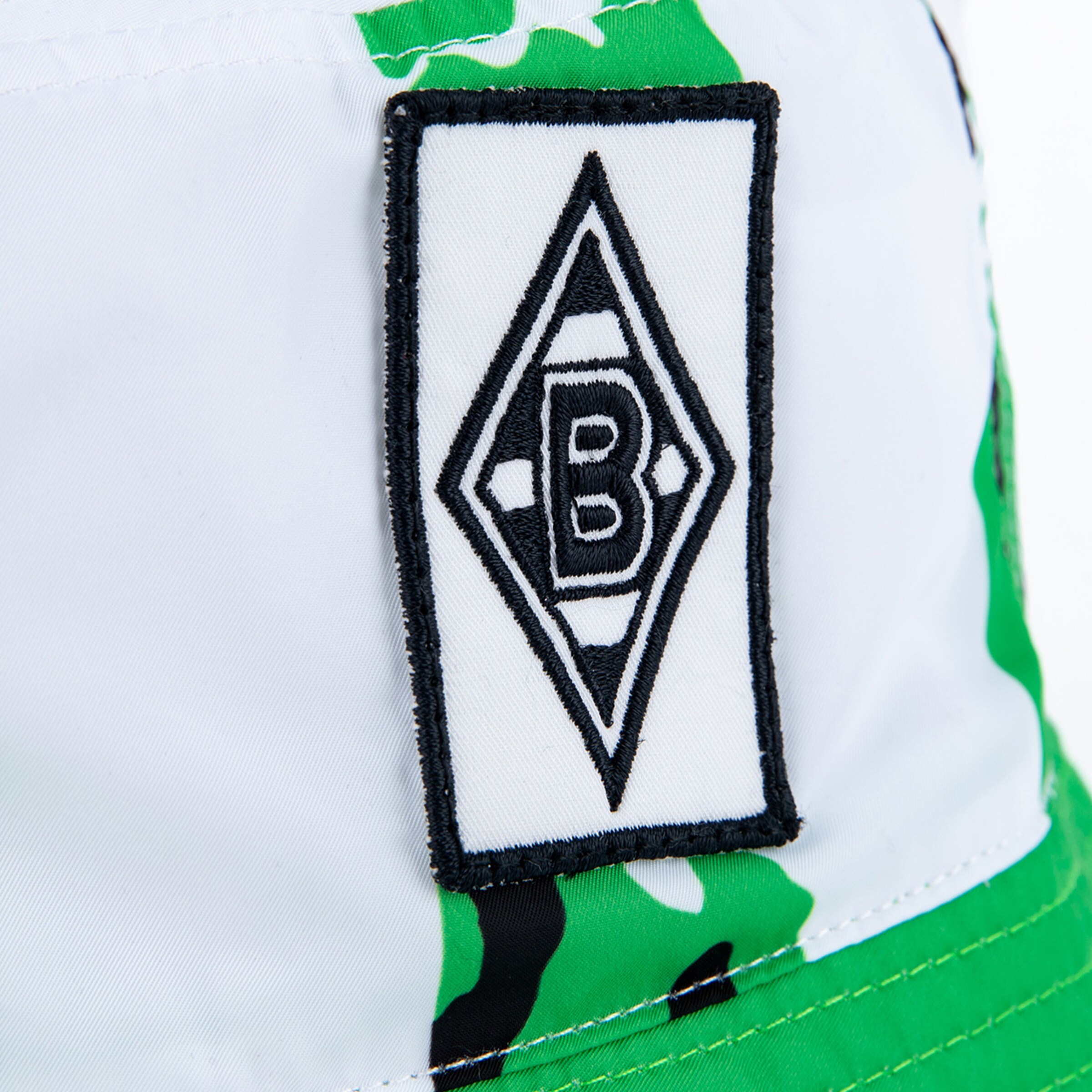Logo von Borussia Mönchengladbach auf einem Hut mit grünem Camouflage-Muster.