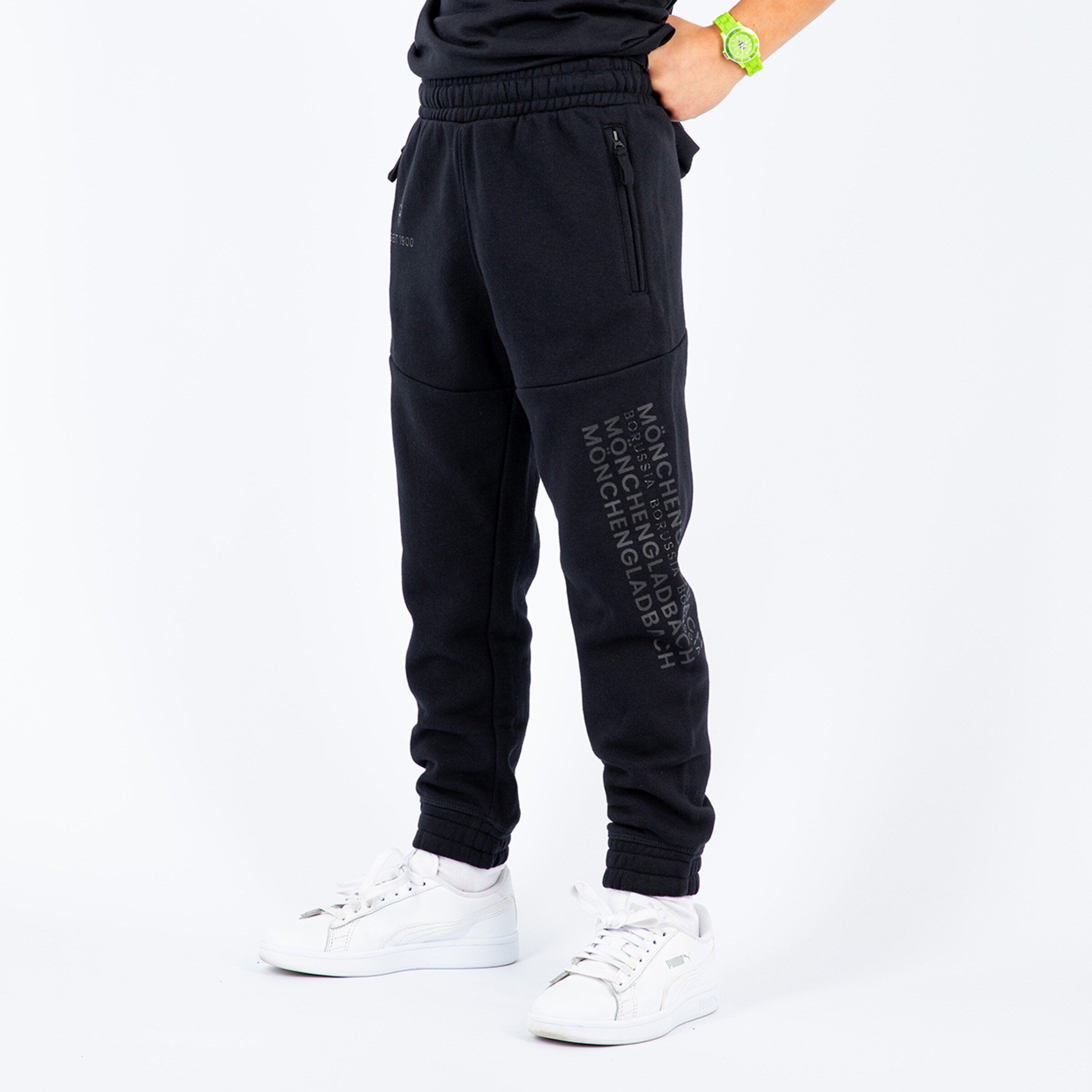 Schwarze Jogginghose mit Reißverschlusstaschen Logo-Print auf der Seite weißes Schuhwerk.