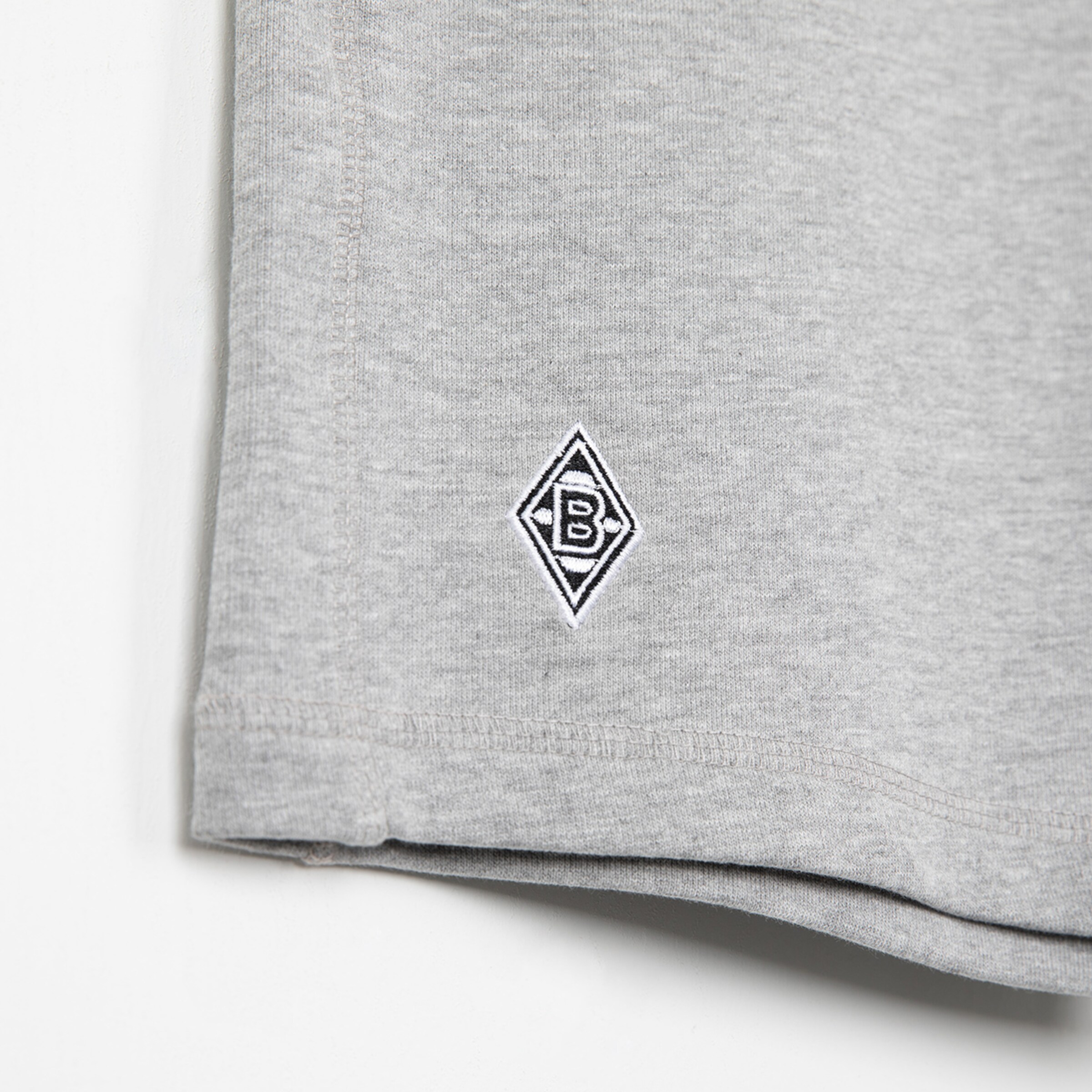 Graues T-Shirt mit aufgesticktem Borussia Mönchengladbach-Logo.