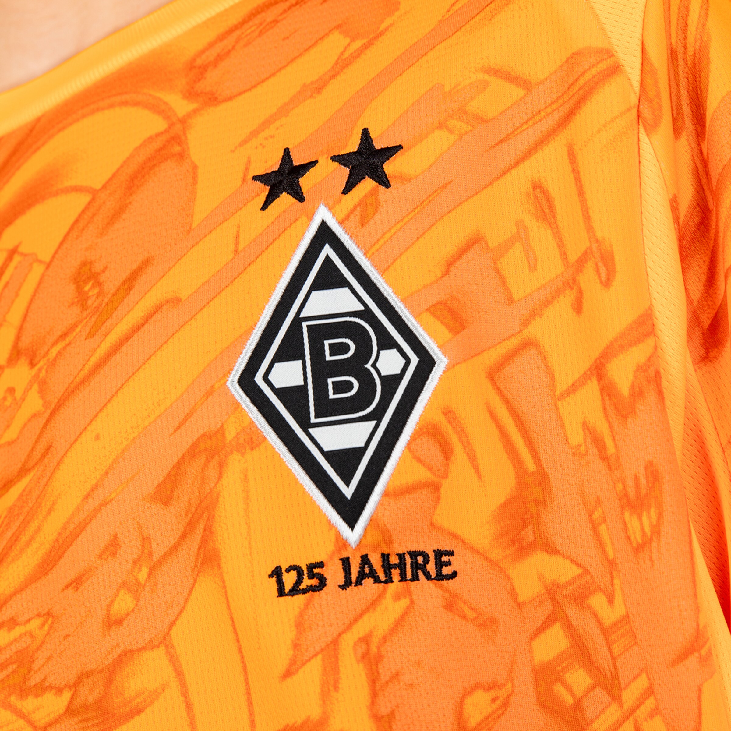 Detailansicht eines fußballtrikots mit dem Borussia Mönchengladbach-Logo und dem Schriftzug 125 Jahre.