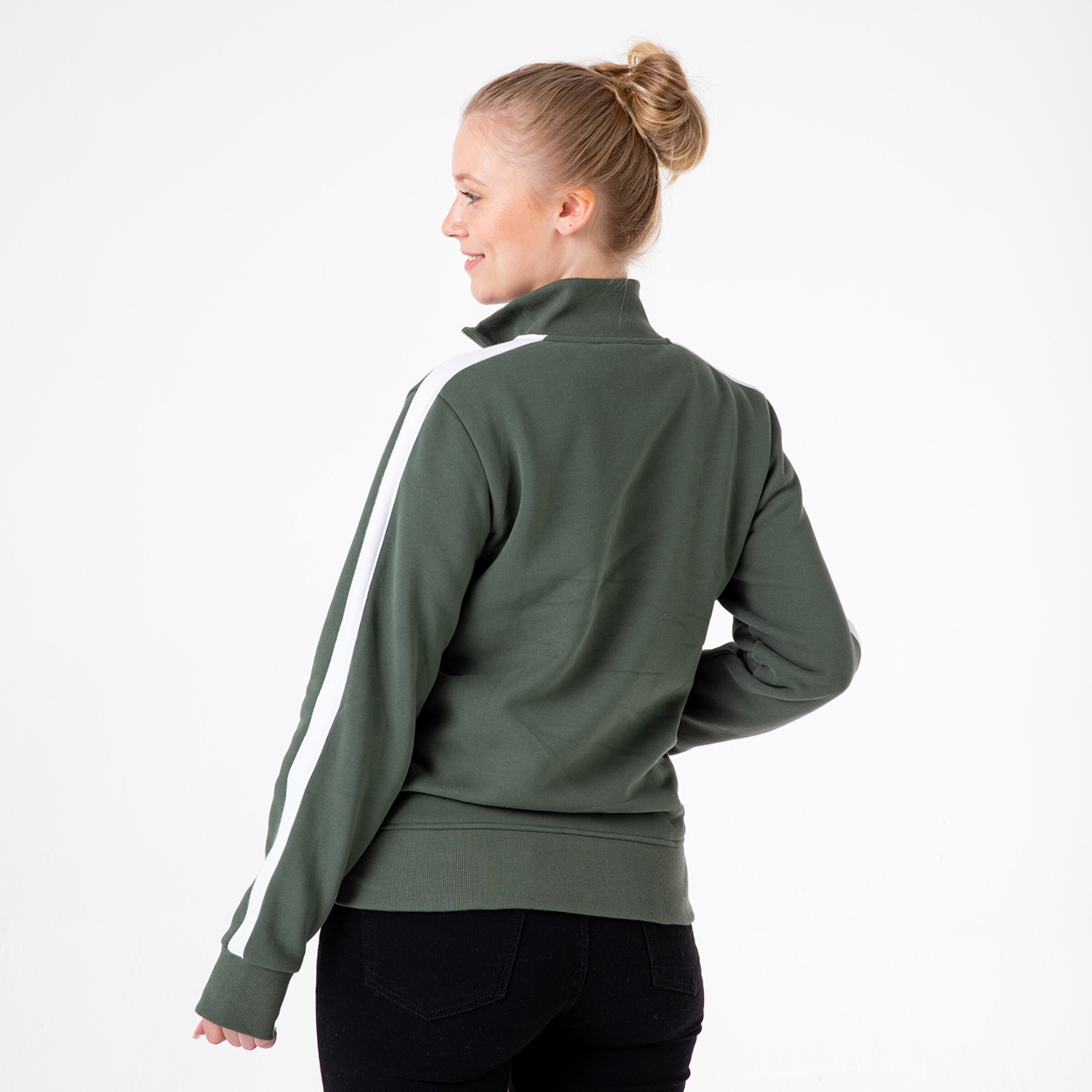 Dame trägt einen olivgrünen Sweatshirt mit weißen Streifen auf den Ärmeln von hinten.
