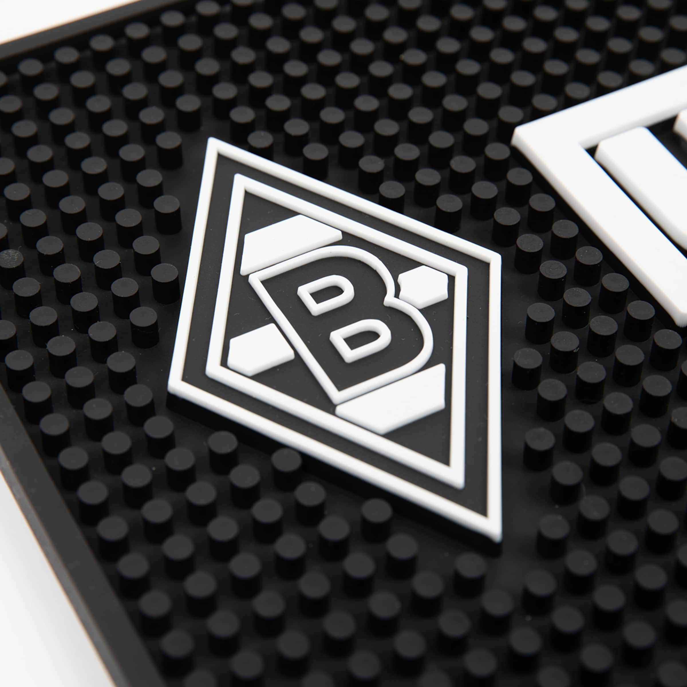 Nahaufnahme einer schwarzen Gummimatte mit dem Logo von Borussia Mönchengladbach (weiß-schwarze Raute mit einem „B“).