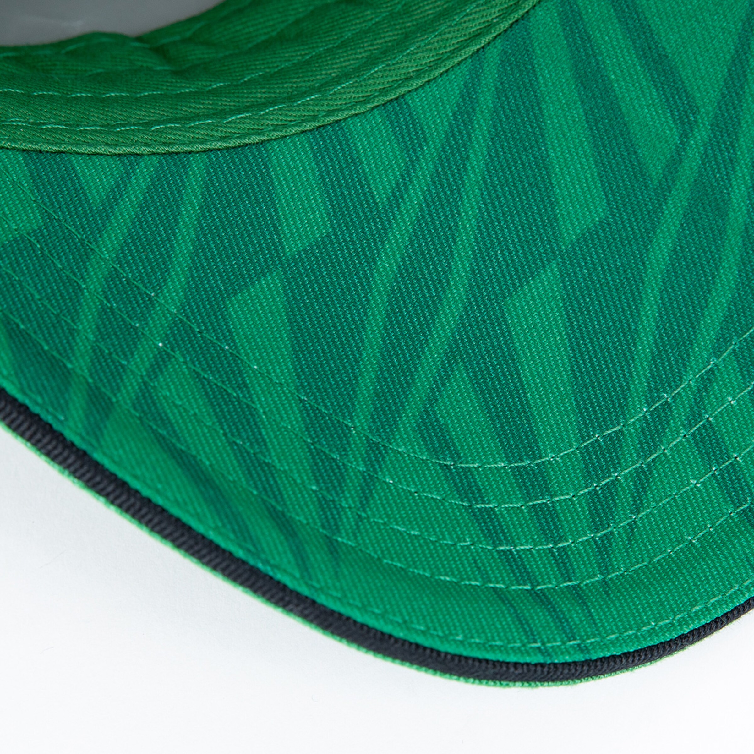 Green cap with geometric pattern and contrasting stitching.