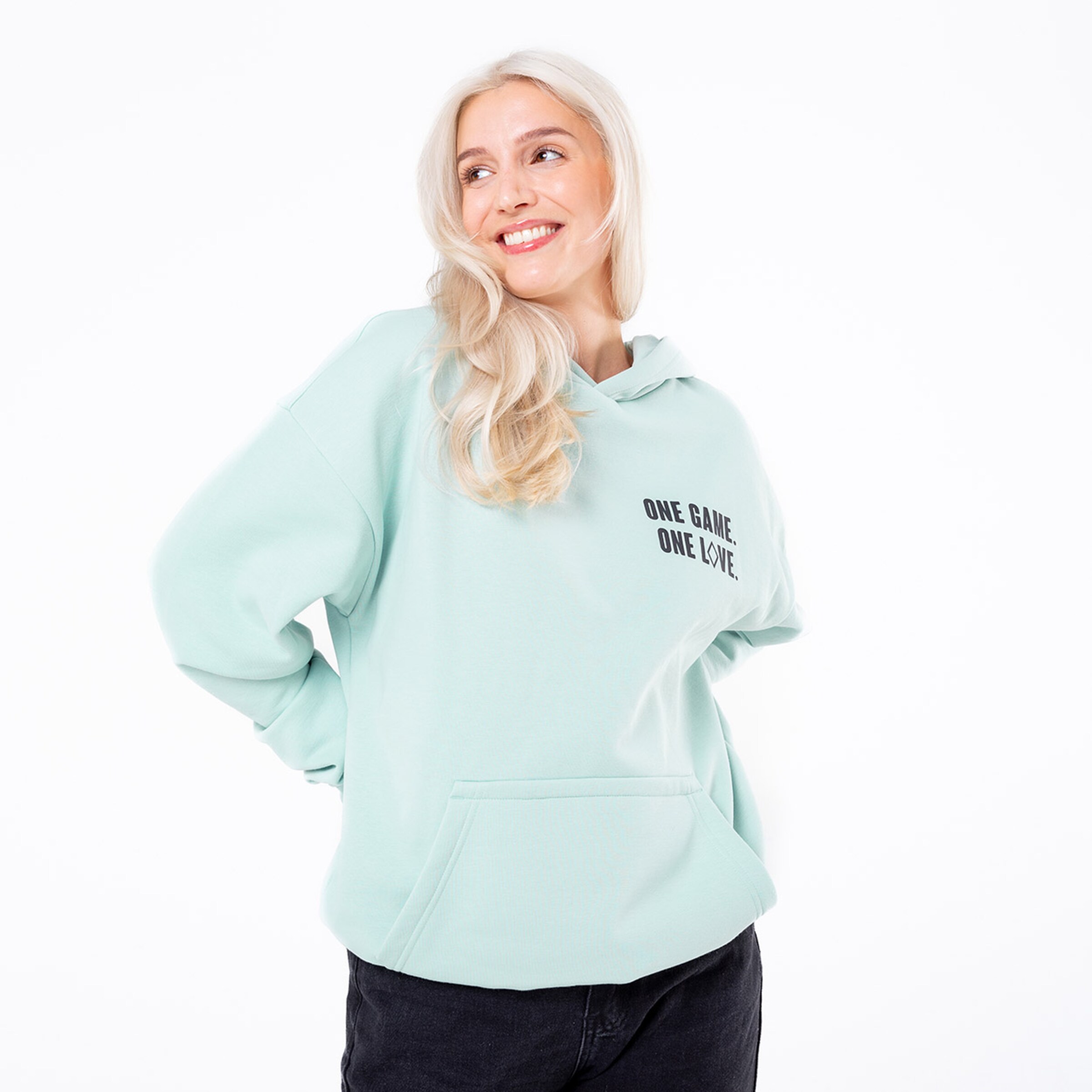 Frau in mintgrüner Kapuzenjacke mit dem Schriftzug ONE GAME ONE LOVE