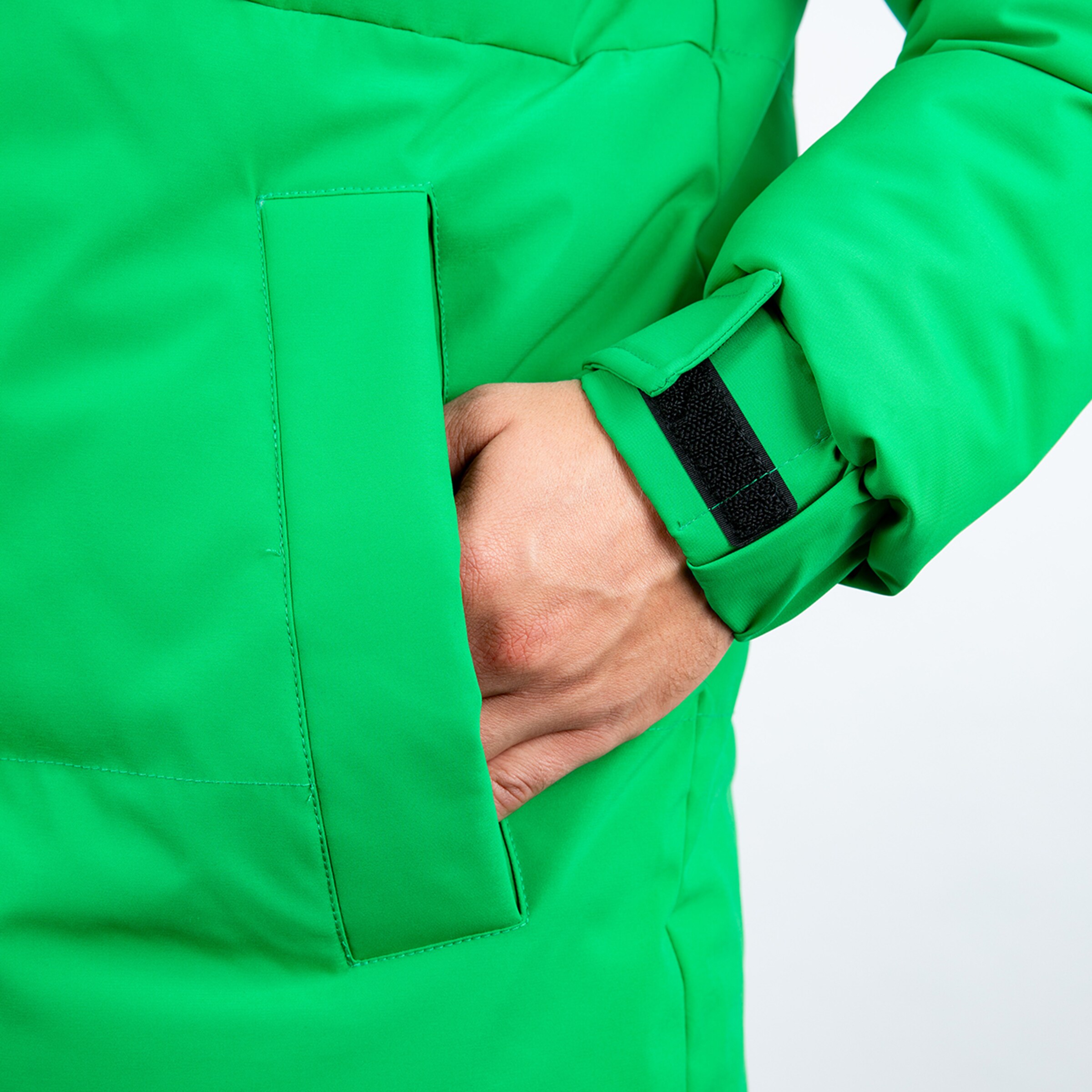 Hand in einer Tasche eines grünen gepolsterten Mantels.