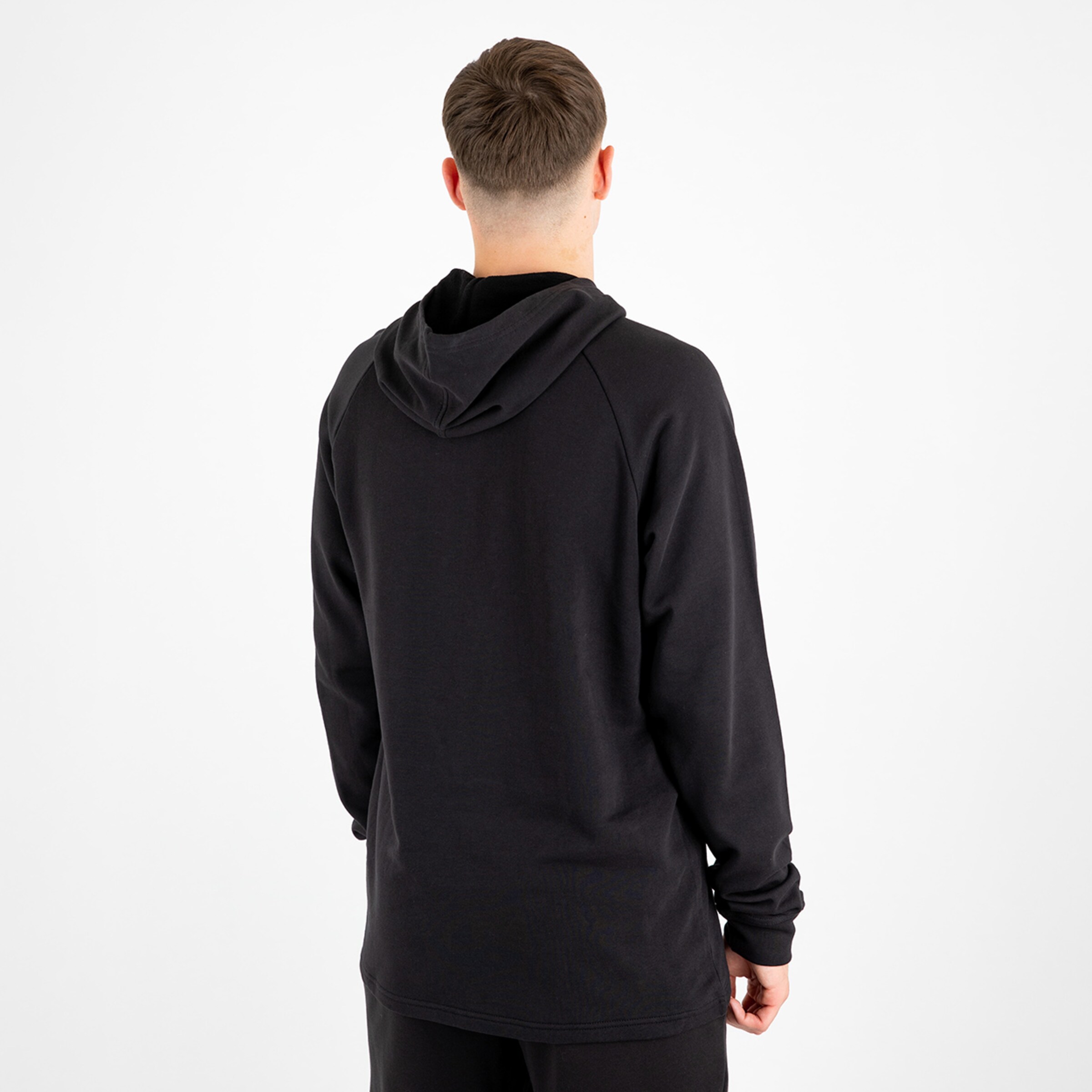 Hinteransicht eines Modells in einem schwarzen Hoodie mit Kapuze.