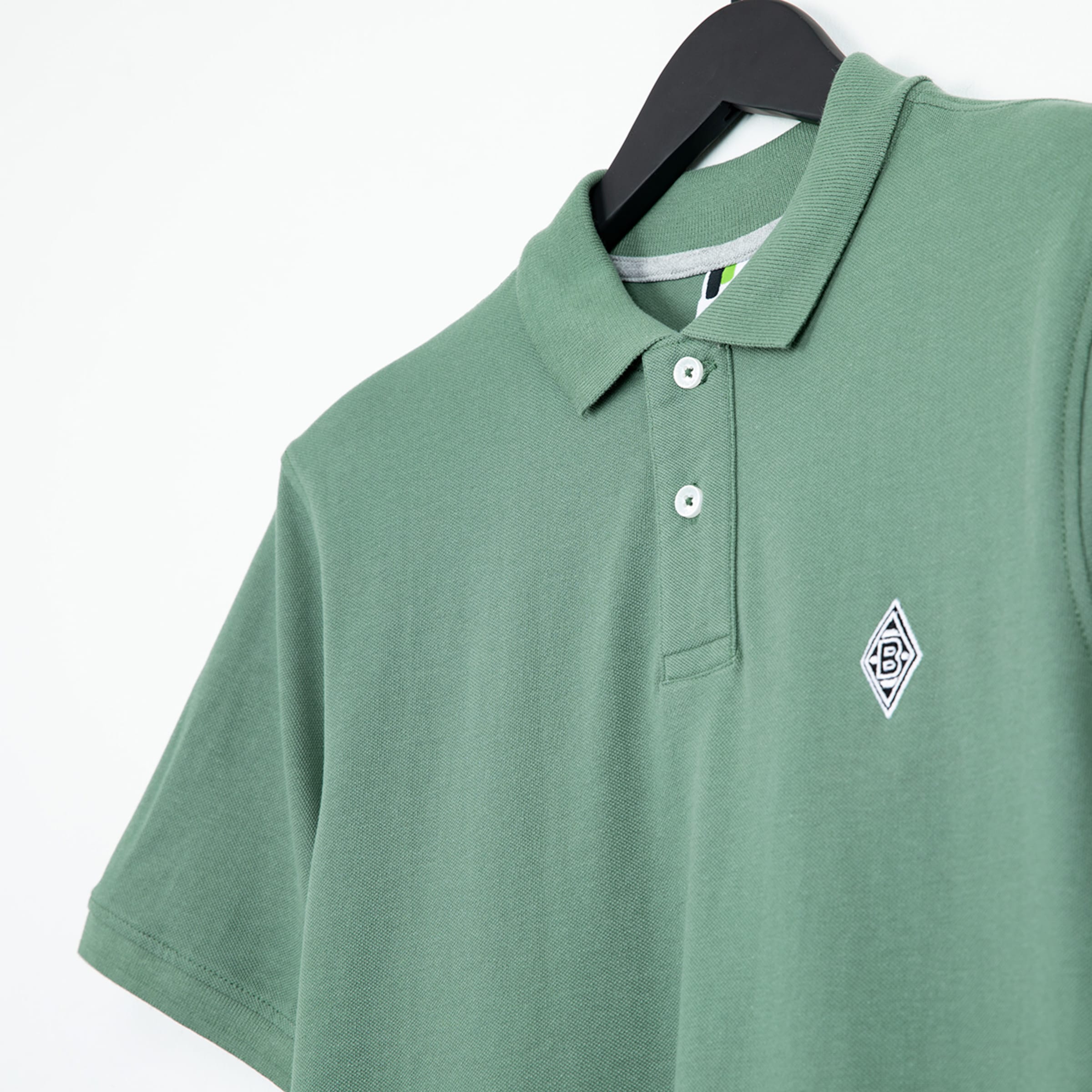 Grünes Poloshirt mit geprägtem Borussia Mönchengladbach-Logo.