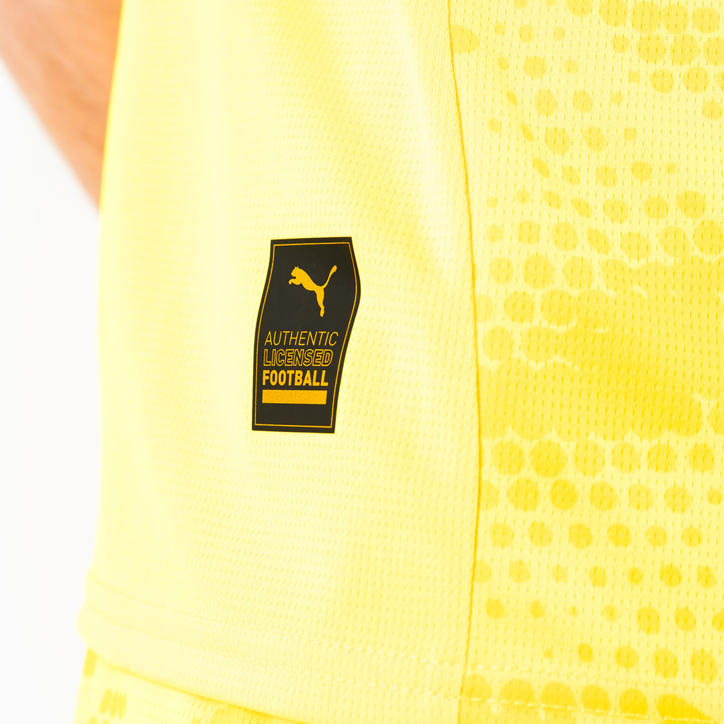Puma-Label auf gelbem Trikot mit der Aufschrift AUTHENTIC LICENSED FOOTBALL