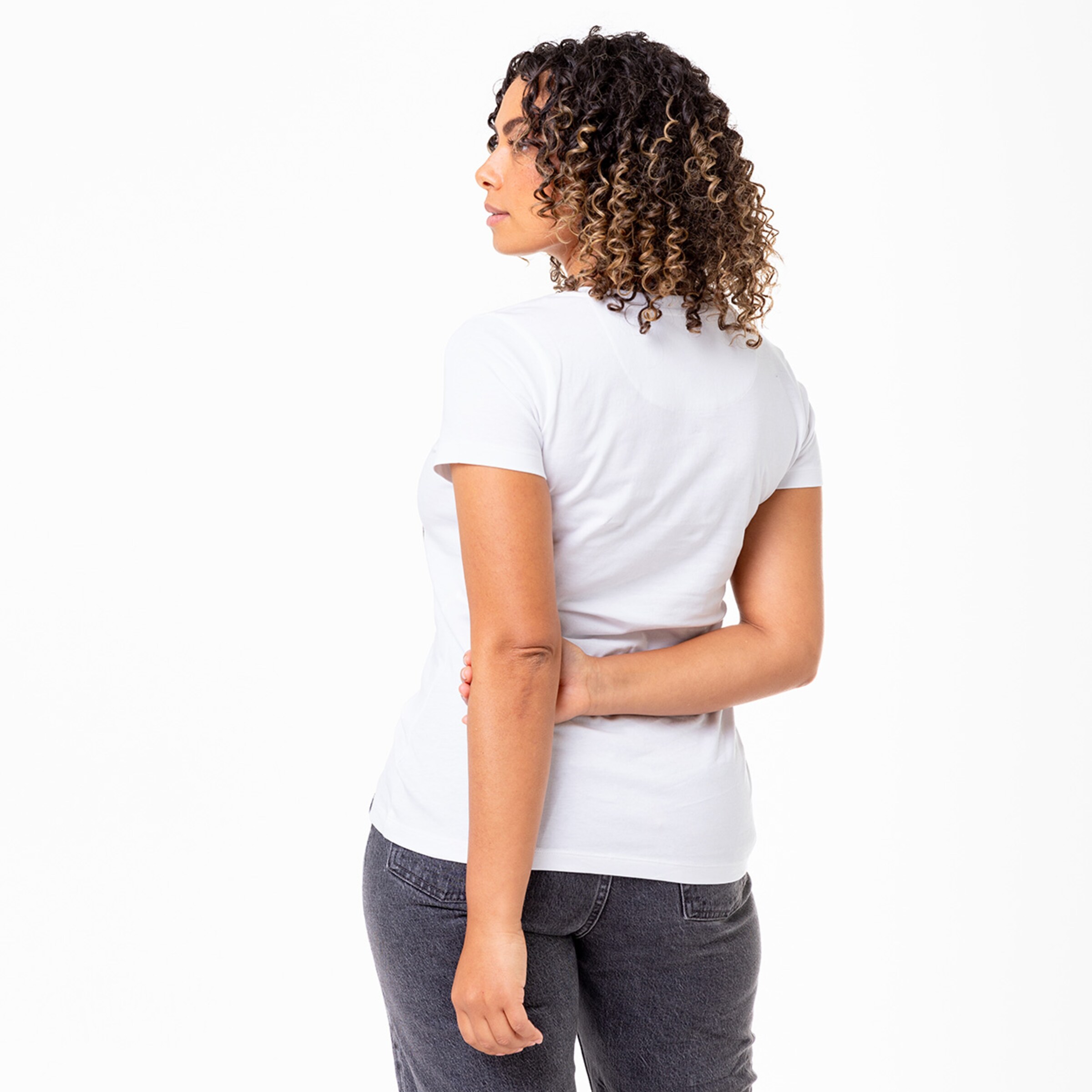 Back view of a woman wearing a white t-shirt and gray jeans.