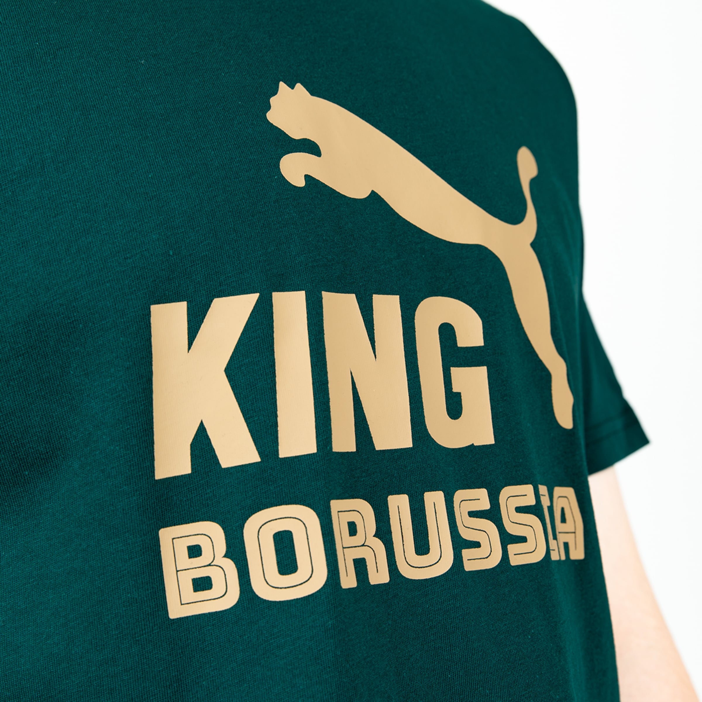 Dunkelgrünes T-Shirt mit goldfarbenem Puma-Logo, fettem „KING“-Schriftzug und konturiertem „BORUSSIA“-Schriftzug.