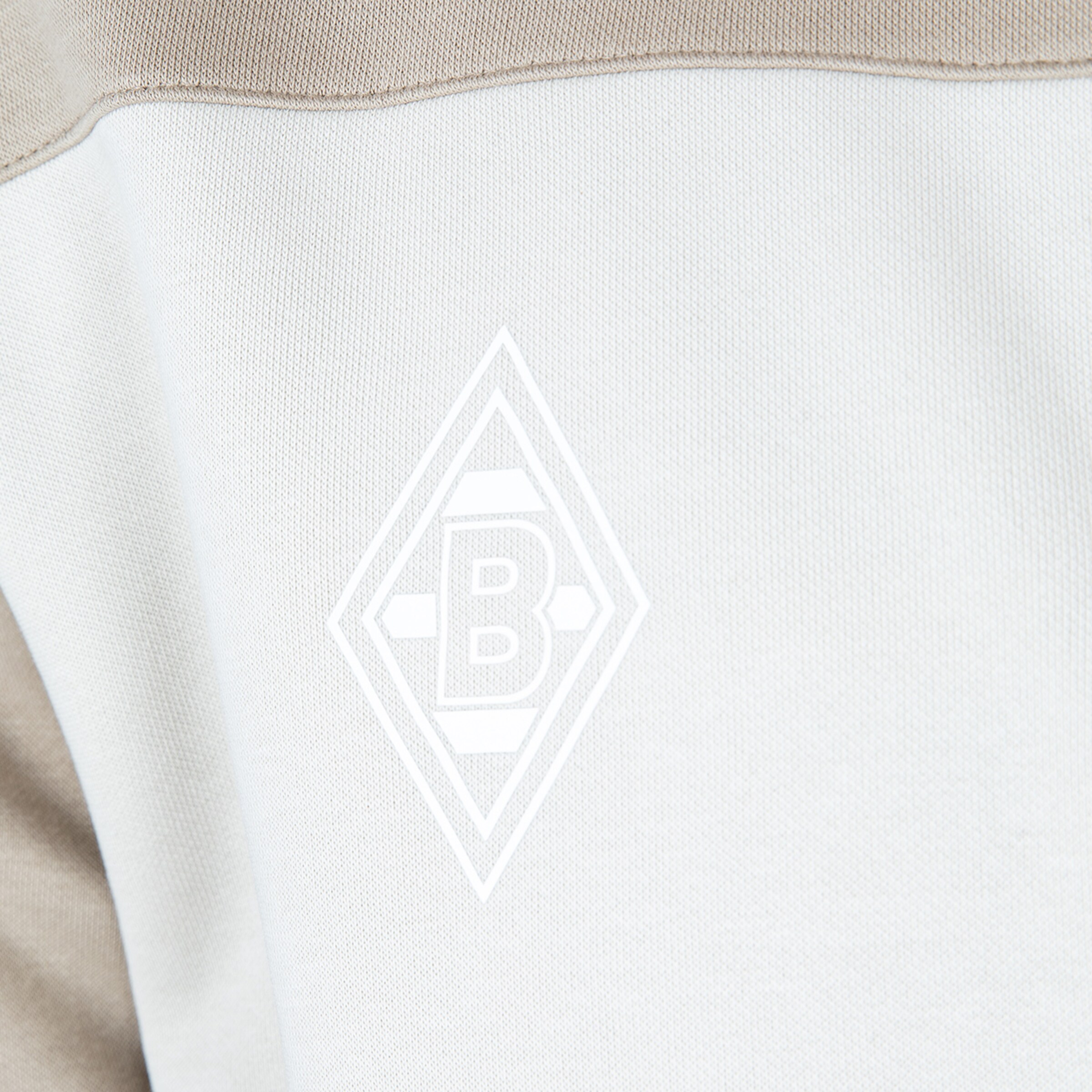 Logo von Borussia Mönchengladbach auf einem hellen Trikot.