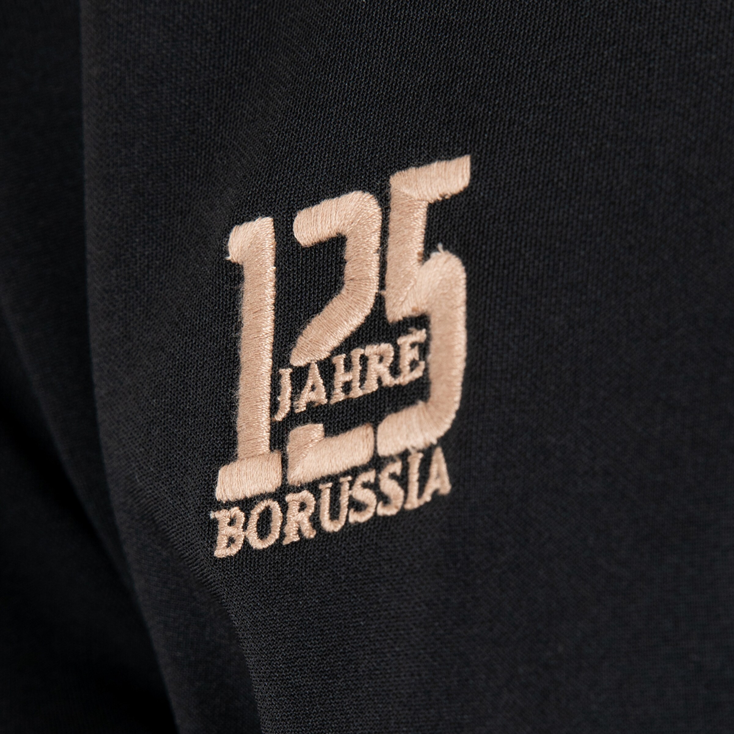 Beige Stickerei auf schwarzem Textil mit der Aufschrift „125 JAHRE BORUSSIA“ zum 125-jährigen Jubiläum.