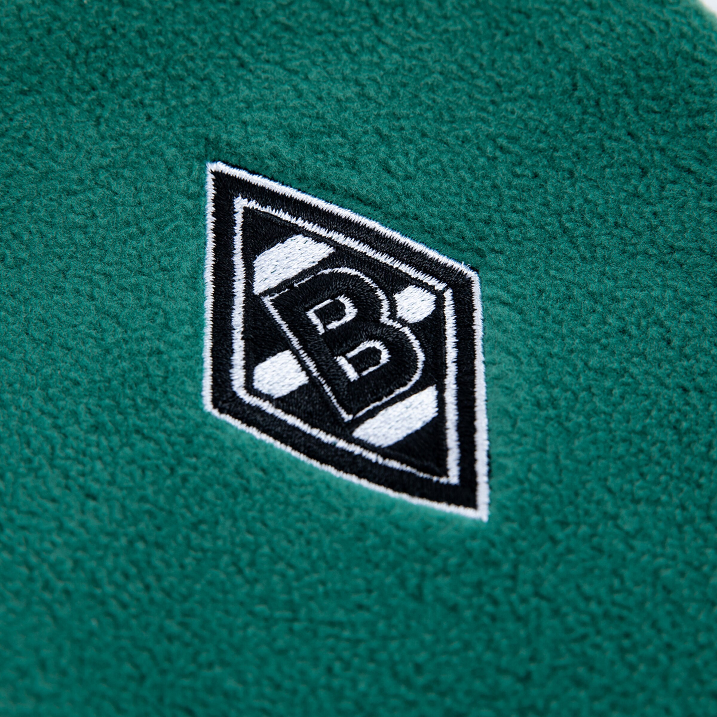 Embroidered Borussia Mönchengladbach logo on green fabric.