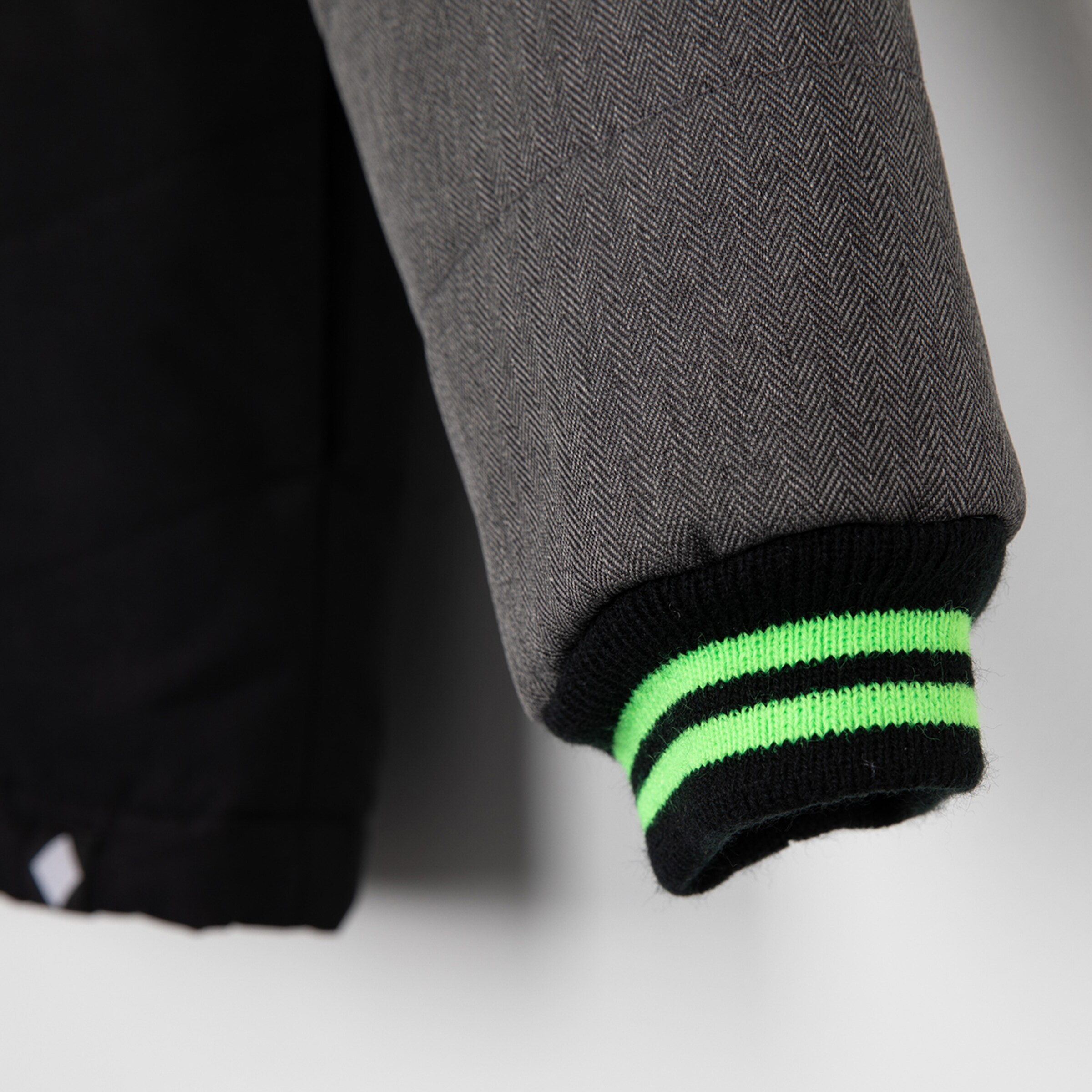 Gray-black jacket with green striped cuff.