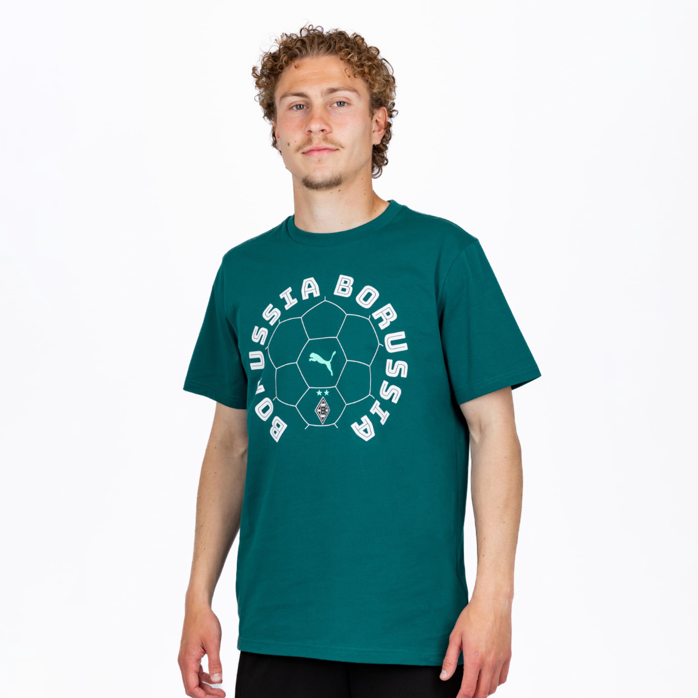 Junger Mann mit lockigem Haar trägt ein dunkelgrünes T-Shirt mit weißer Fußball-Grafik, „BORUSSIA“-Schriftzug, Puma- und Borussia Mönchengladbach-Logo, vor weißem Hintergrund.