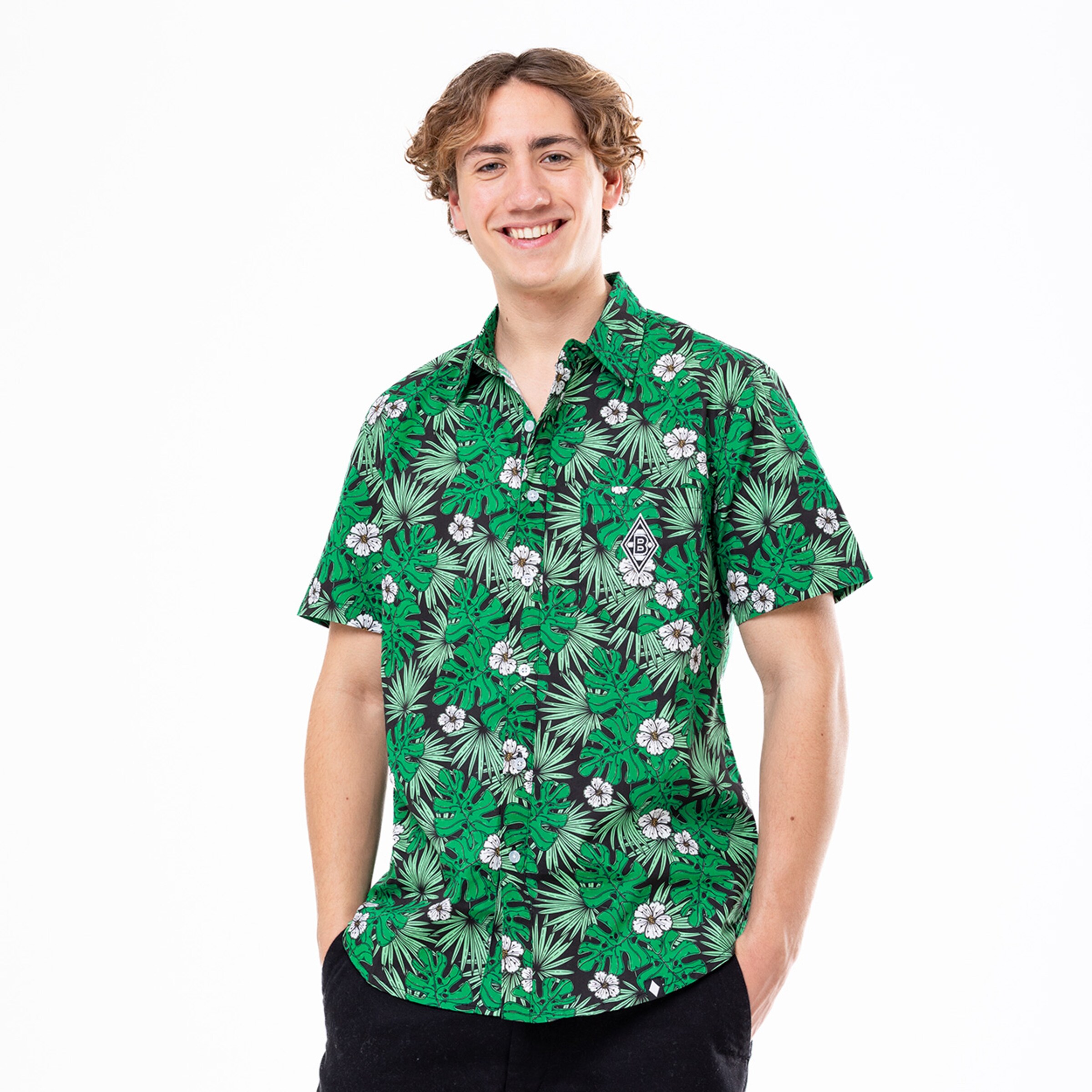 Junger Mann trägt ein grünblühendes Hemd mit tropischem Muster.