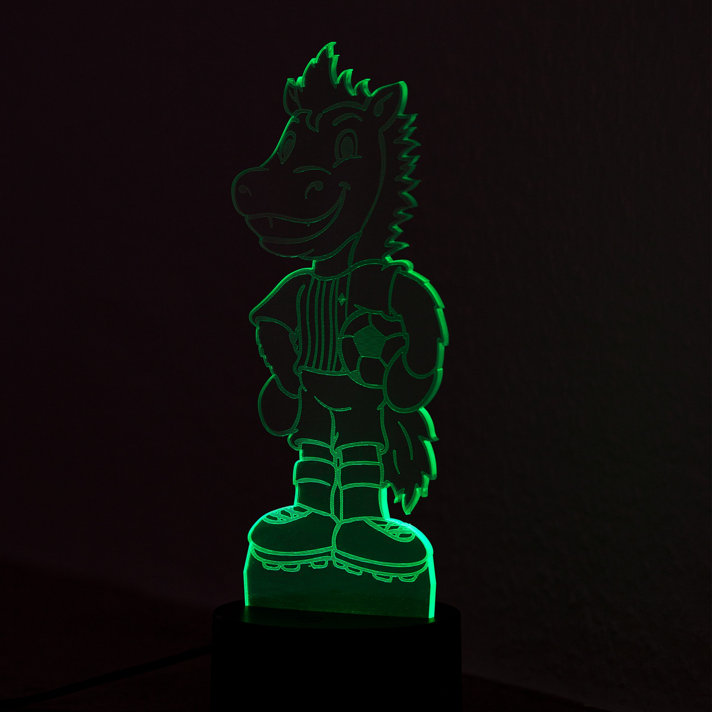 Grüne LED-Lampe in Form von Jünter, dem Maskottchen von Borussia Mönchengladbach, mit Fußball und Sportkleidung vor dunklem Hintergrund.