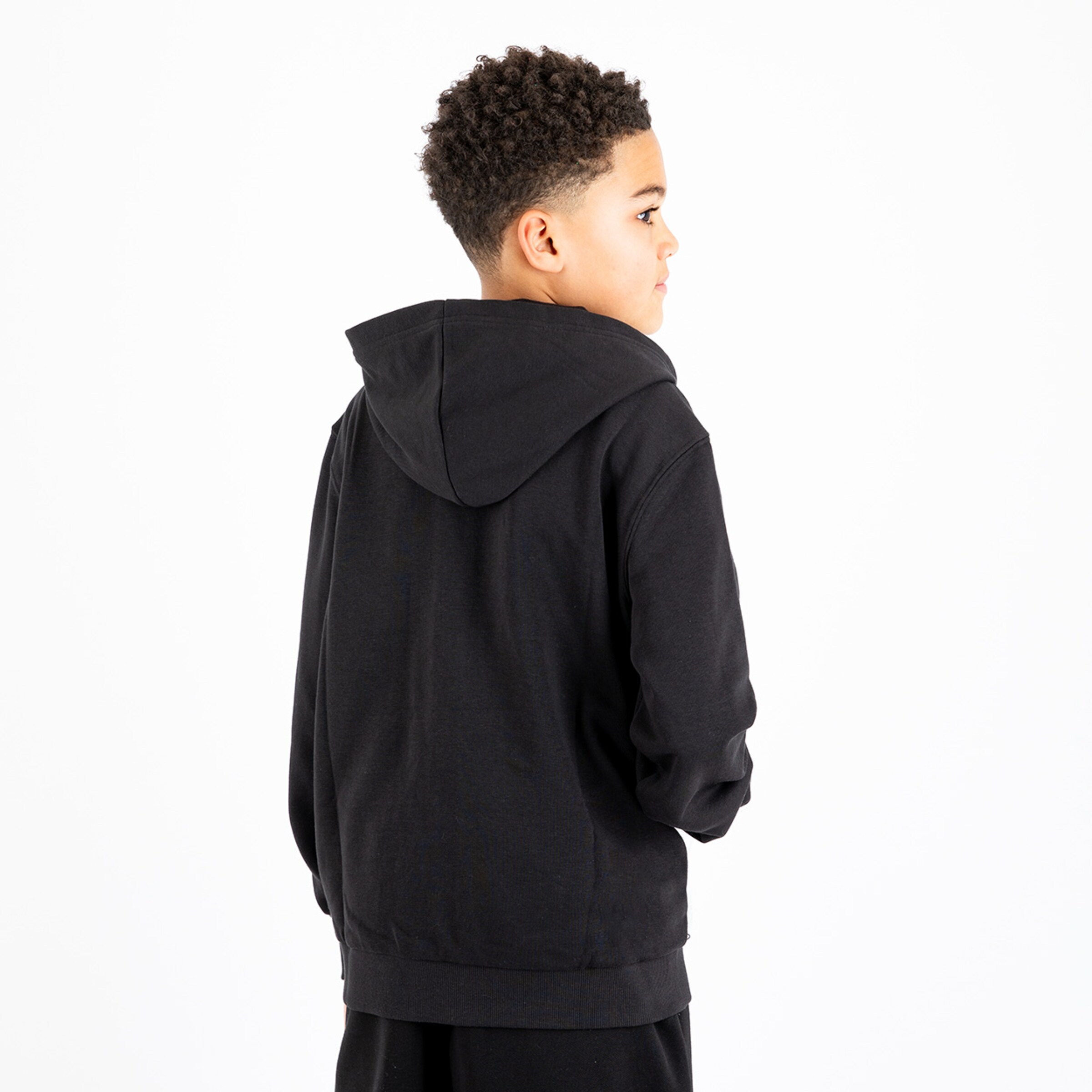 A boy wearing a black hoodie photographed from the back.
